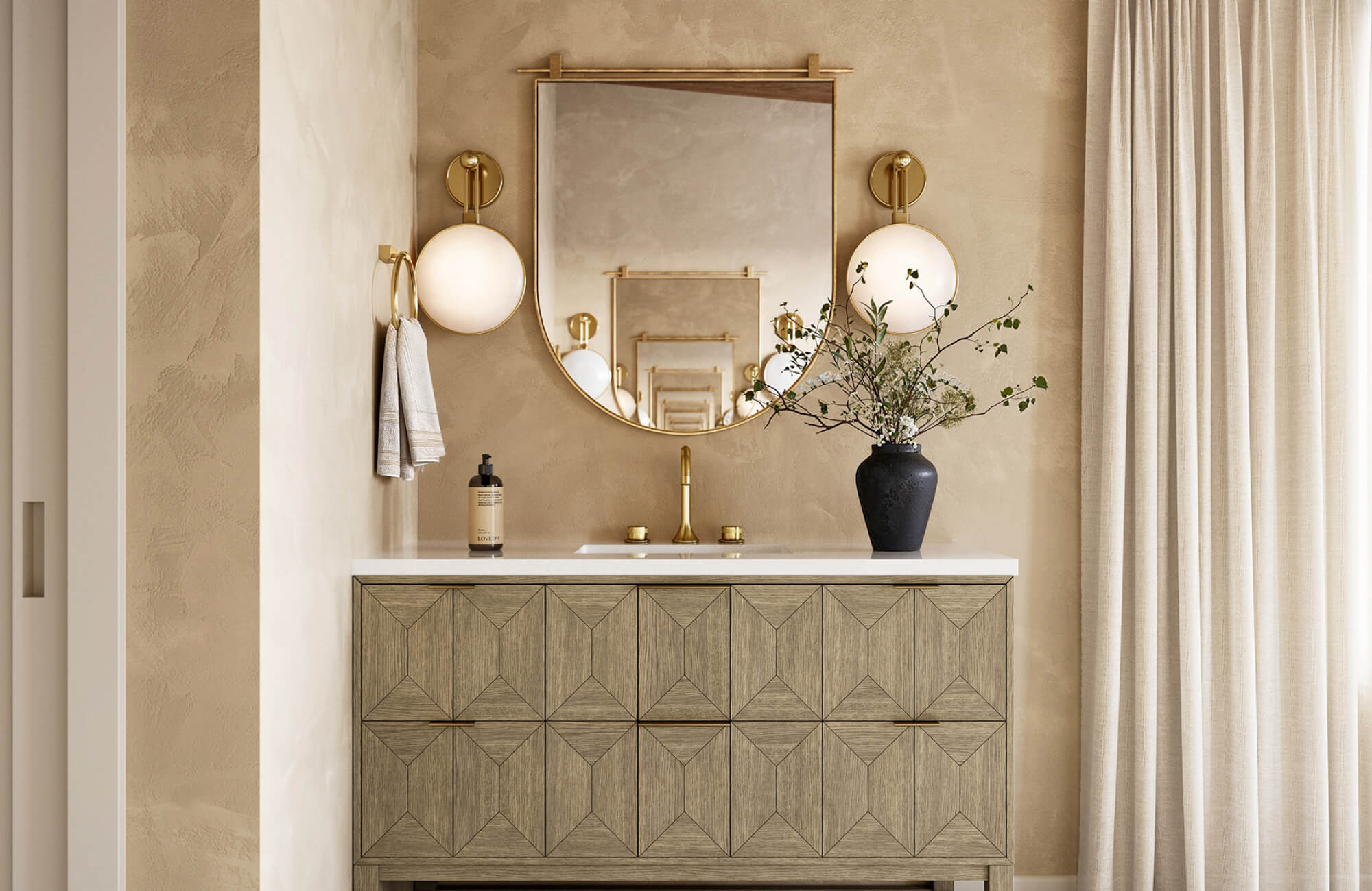 Geometric wood vanity with a white countertop pairs elegantly with brass fixtures and globe sconces against a warm textured wall.