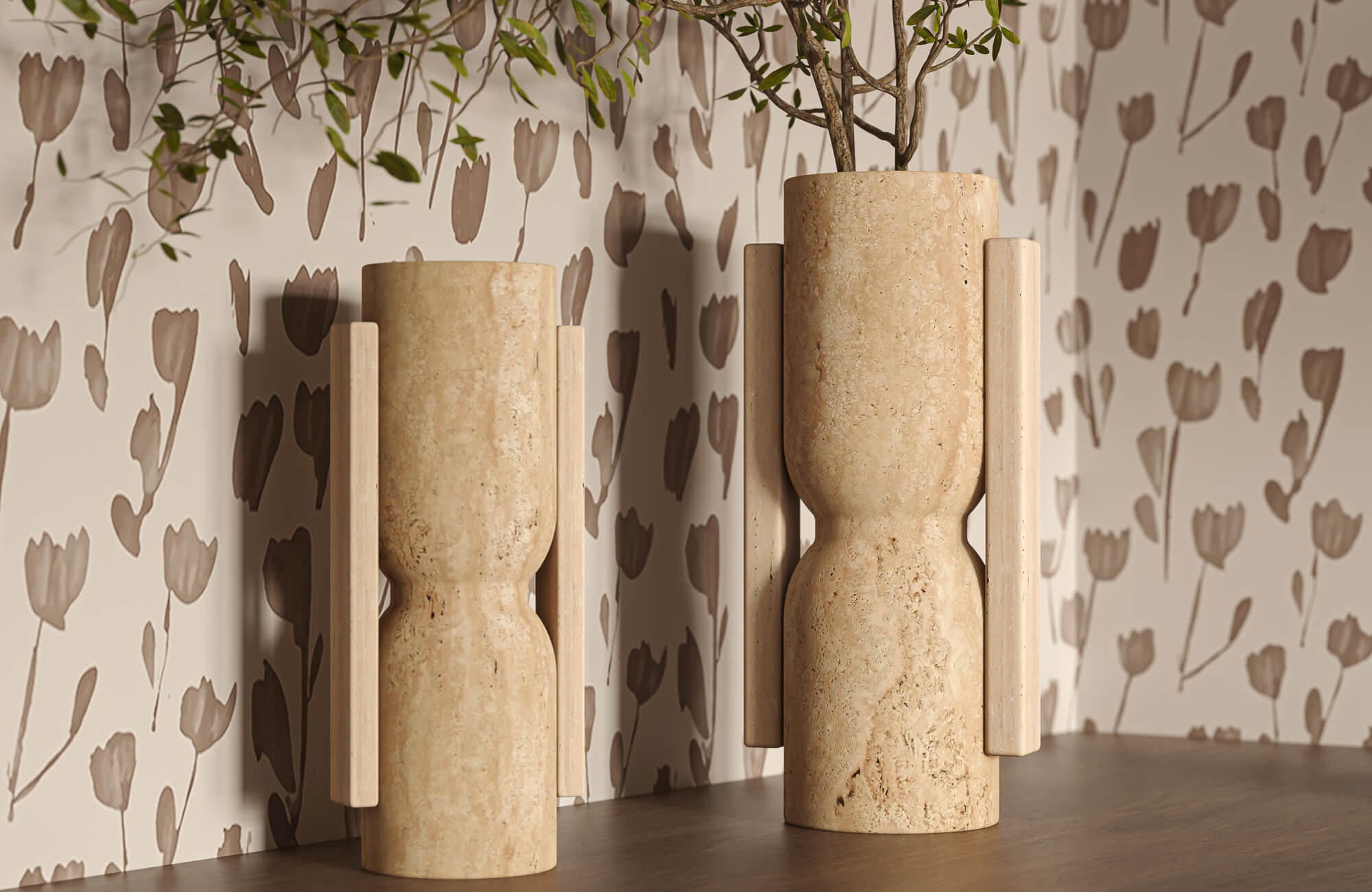 Tall beige decorative vases with carved stone surfaces and wood details are placed on a wood console, set against a soft, floral-patterned wall.