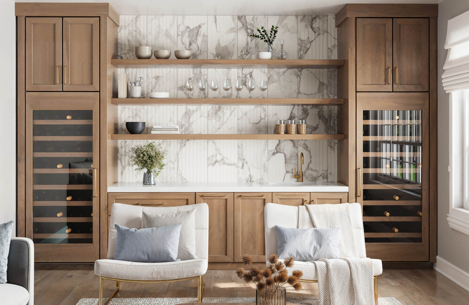 Warm wood cabinetry and open shelving frame a stunning marble-look feature wall, complete with a brass faucet and integrated wine storage.