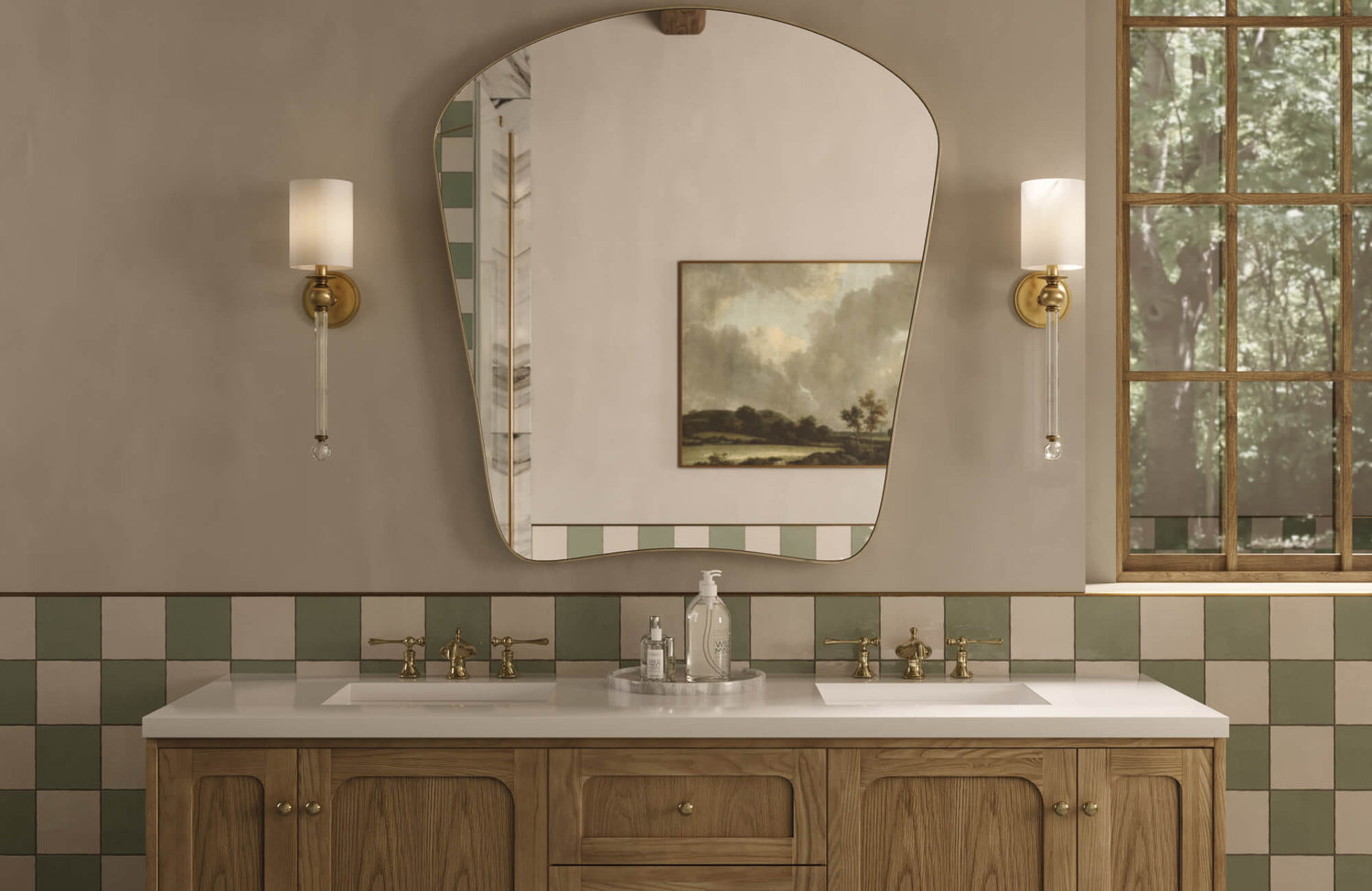 Bathroom vanity with soft green and beige checkerboard wall tiles, featuring brass sconces, a sculpted mirror, and a warm oak cabinet for a timeless look.