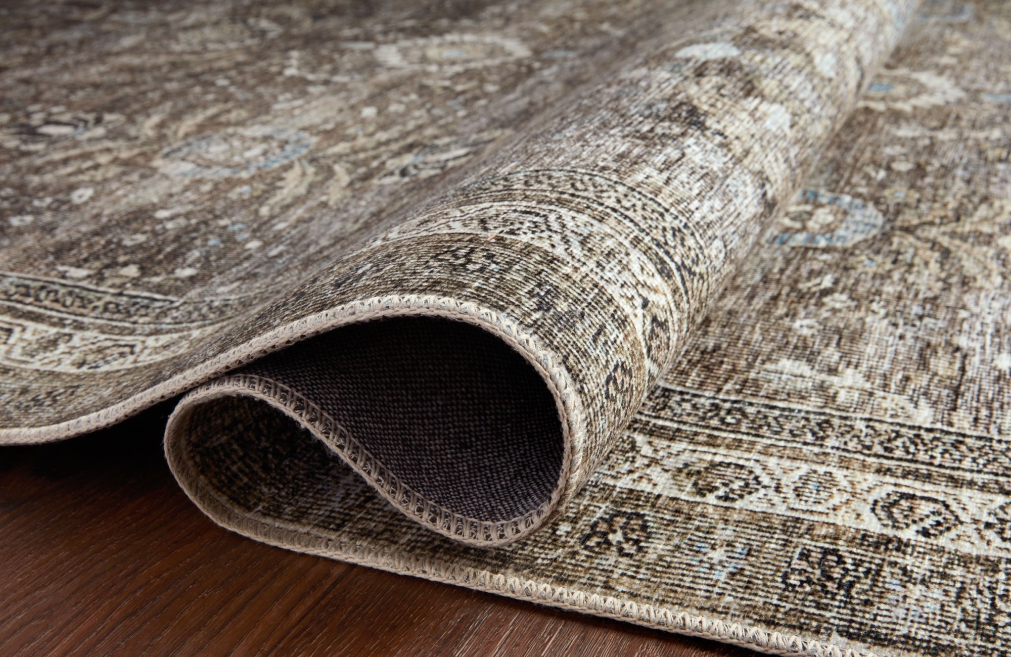Polyester rug with distressed pattern showing tightly looped pile and natural texture on dark wood floor