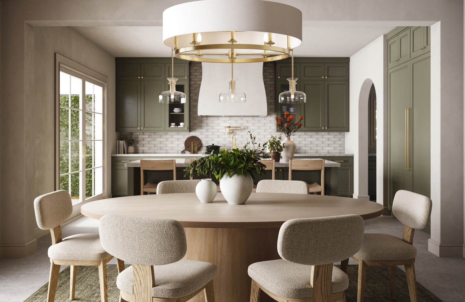 Elegant kitchen and dining area featuring a large round chandelier with gold accents and glass pendant lights, casting a warm, inviting glow over the soft beige seating and olive-green cabinetry.