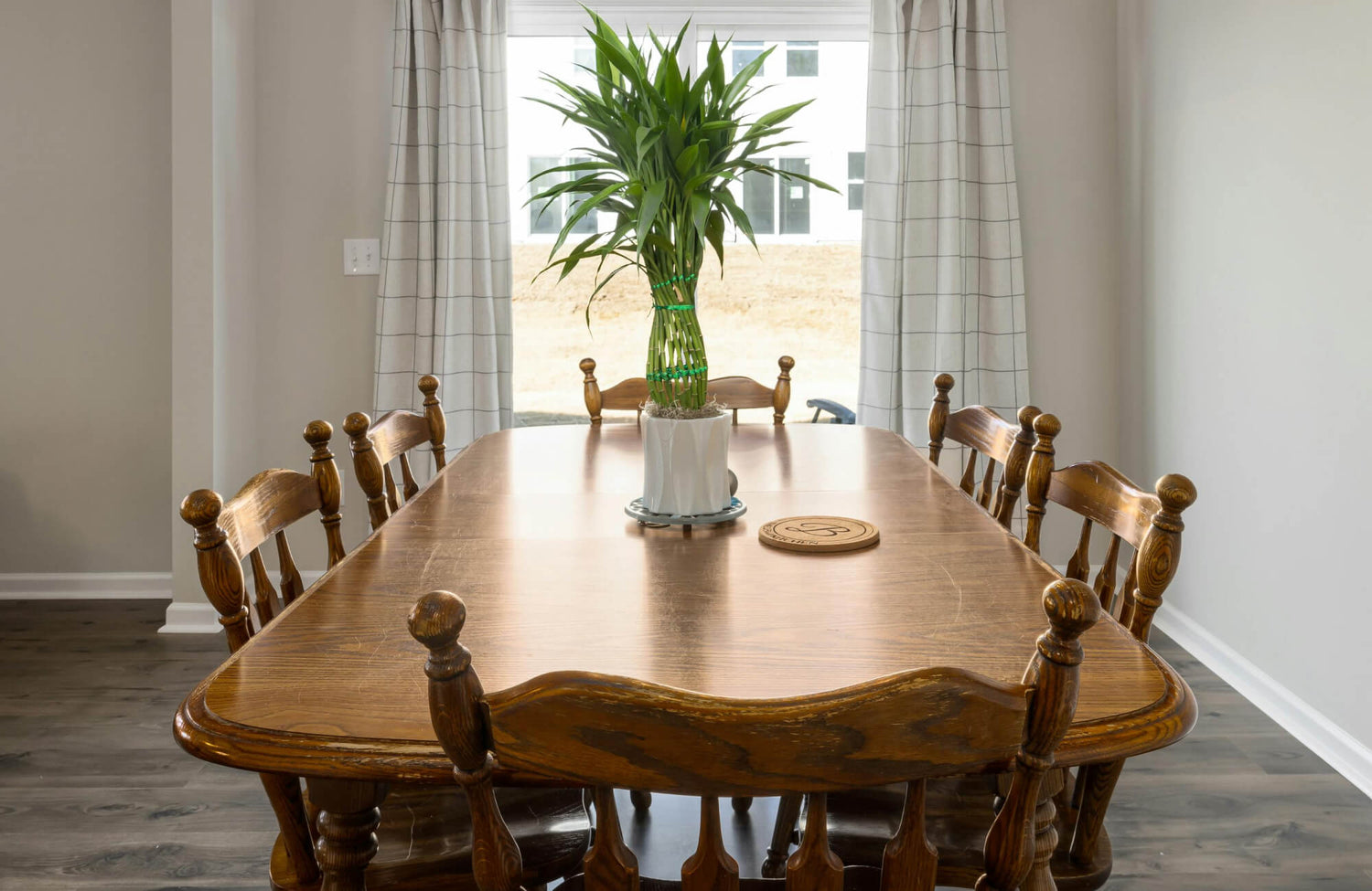 Solid wooden dining table with chairs arranged for daily meals, showing a smooth surface suited for regular family use.