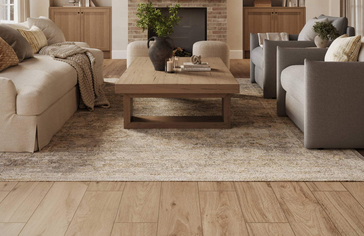 Warm wood-look tile flooring paired with a grey-toned textured rug creates a cozy contrast in this inviting living room.