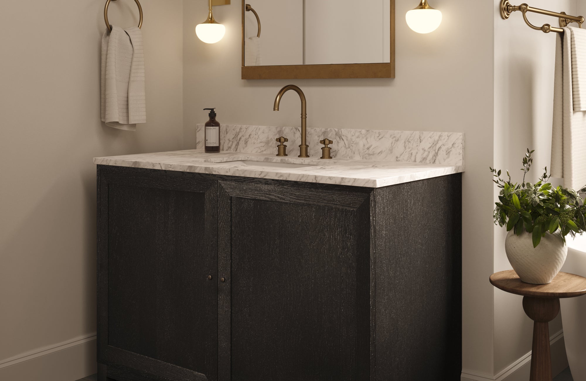 Stylish bathroom vanity in rich black finish with marble top and brass accents, highlighted by soft lighting and minimal decor.