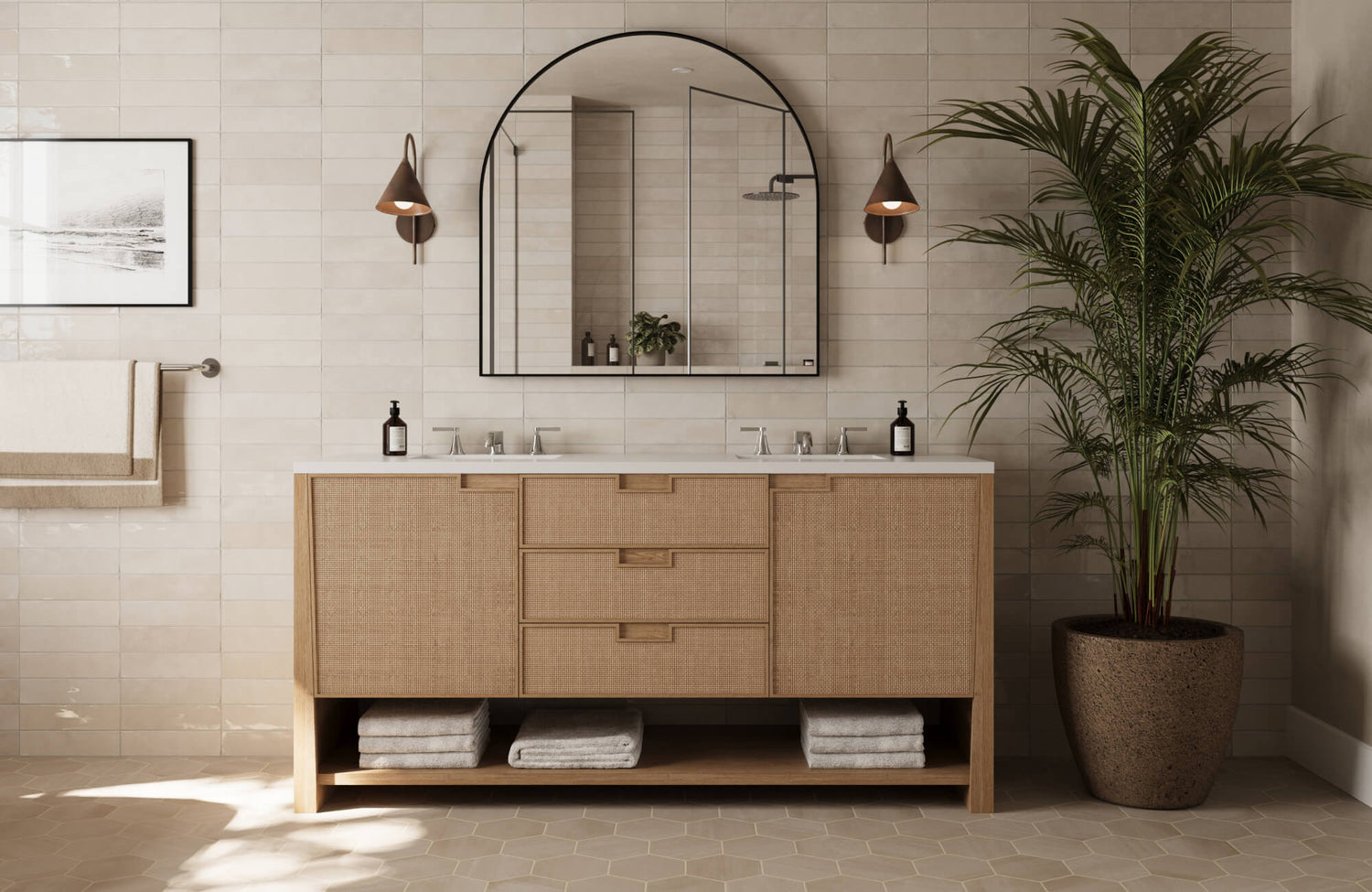 Natural-toned bathroom featuring a rattan-front vanity, large arched mirror, and soft beige tile walls for a breezy, spa-inspired look.