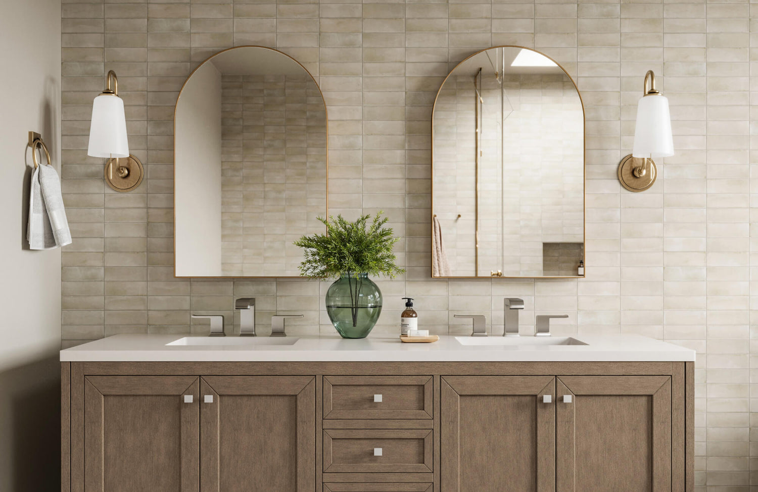 Bathroom with dual arched mirrors, wood vanity, matte brass sconces, and soft beige tile walls for a warm, spa-like feel.