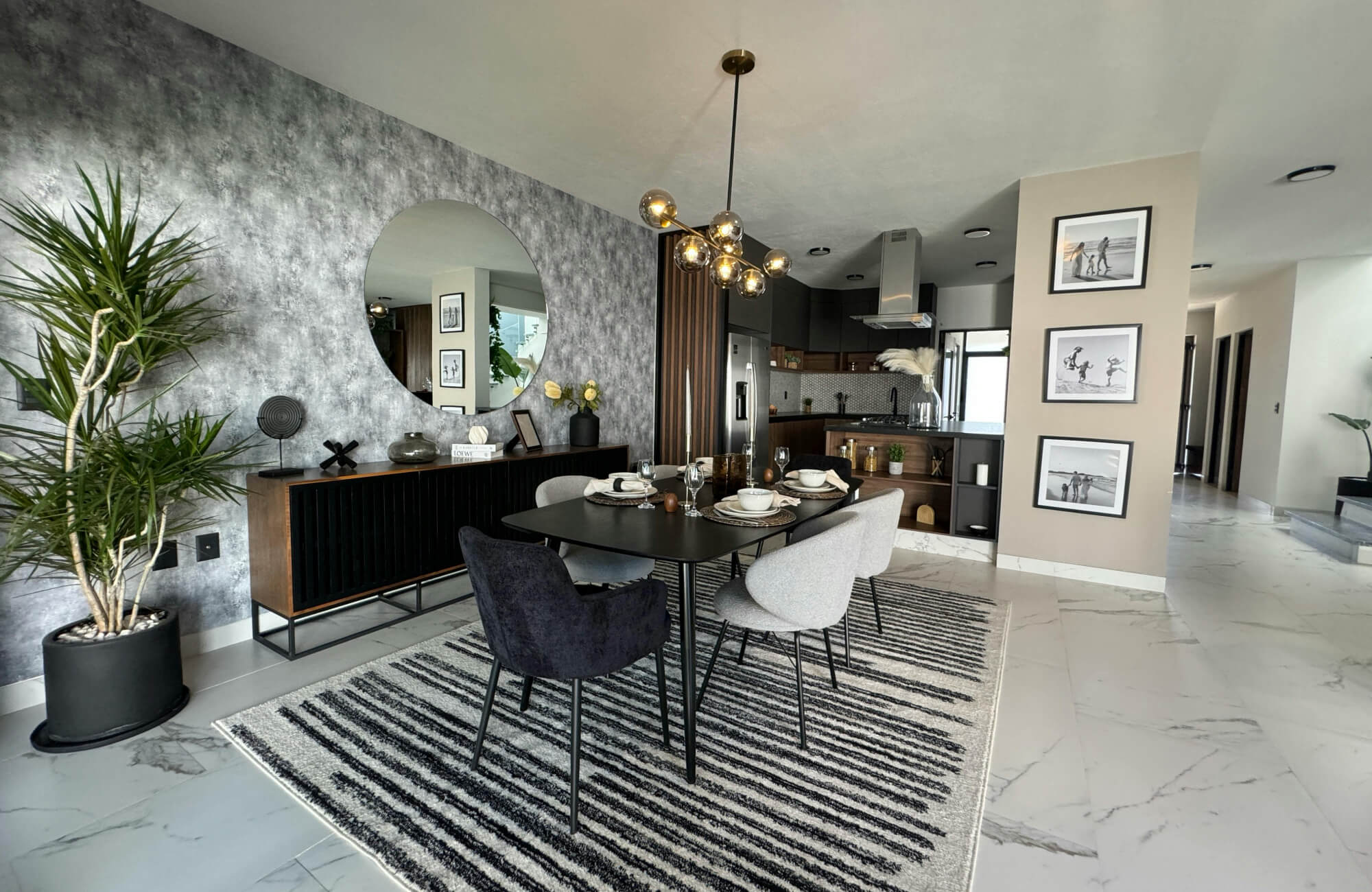 Large round mirror reflecting a modern dining room with a dark table and a patterned rug