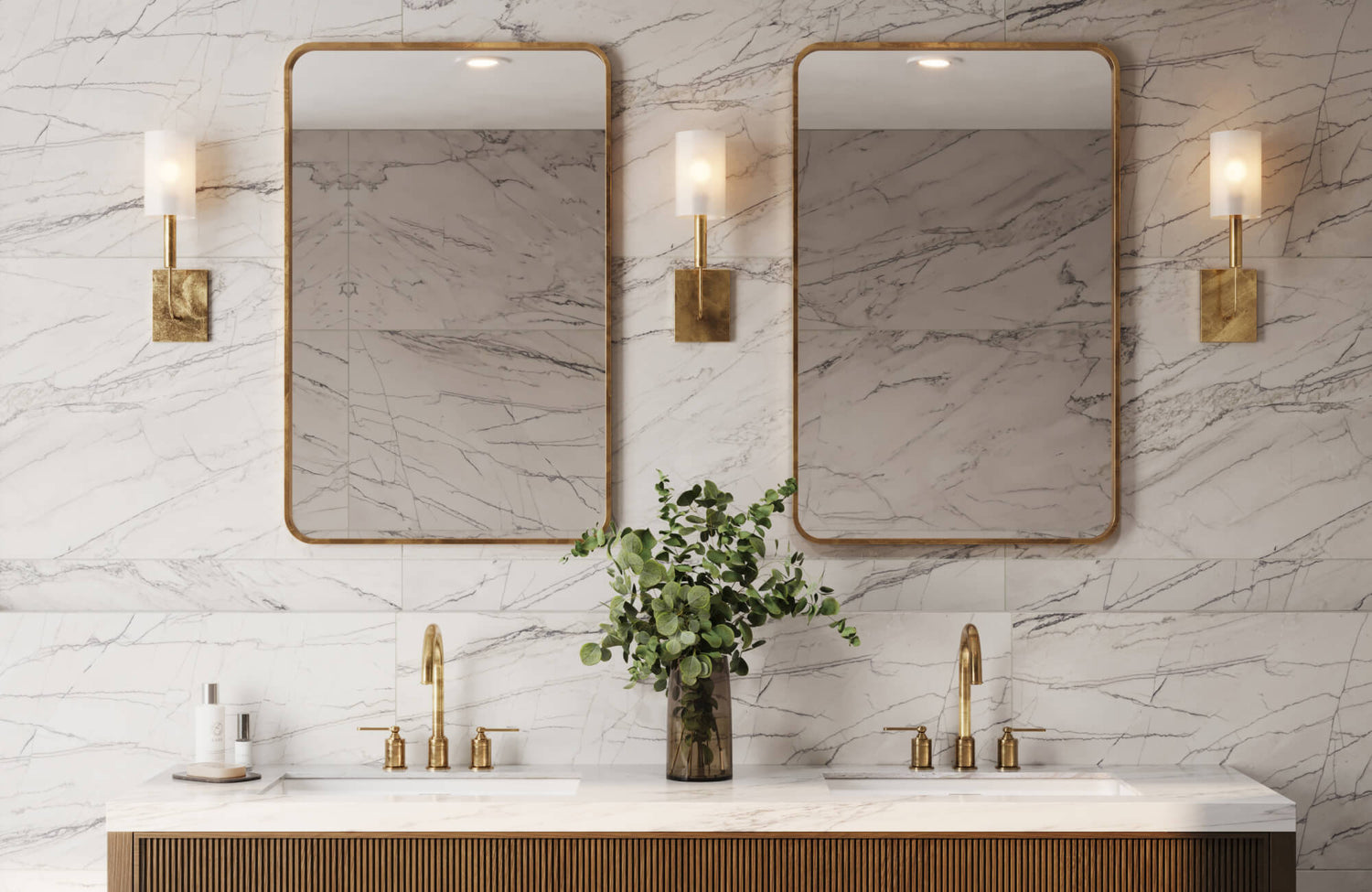 Elegant bathroom vanity with gold fixtures, double mirrors, and marble look wall tiles in a soft veined pattern.