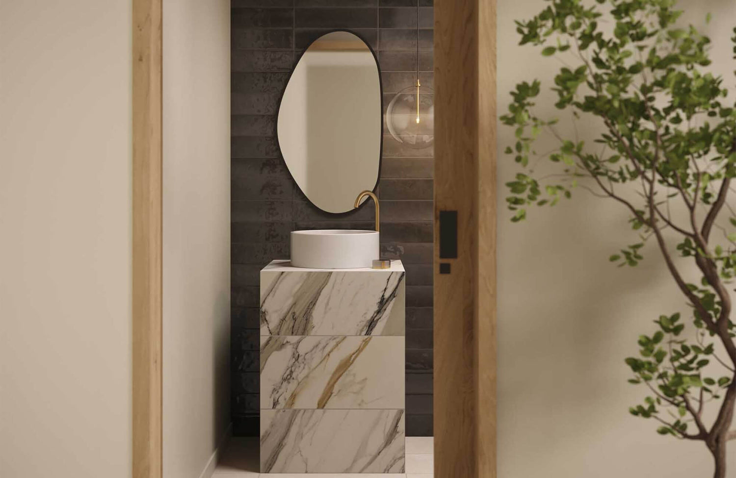 Modern bathroom featuring a marble look tile vanity, paired with a round mirror and brass faucet against a subtly textured dark backdrop.