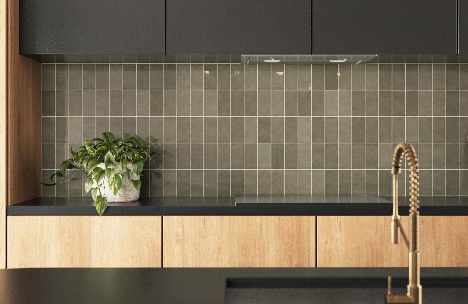 Modern kitchen backsplash featuring glossy olive green square tiles with light grout, black countertops, and natural wood cabinetry.