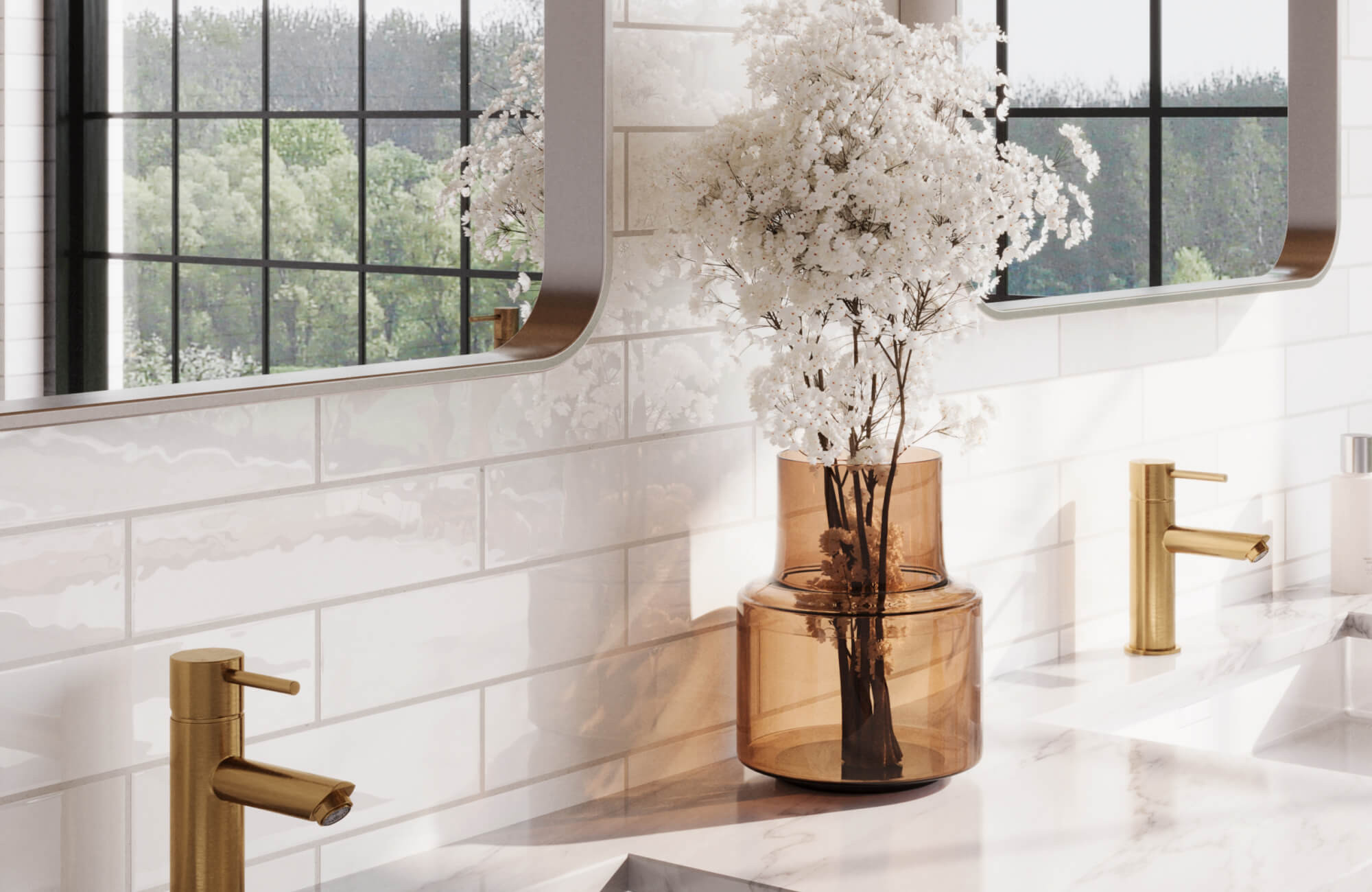 Amber glass vase holding delicate white flowers on a marble countertop, set against glossy white subway tiles and gold faucets.