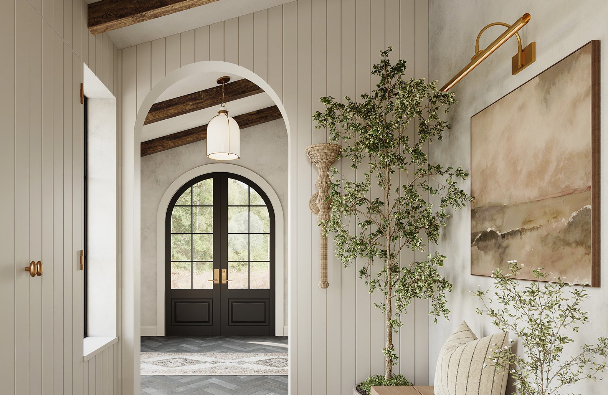 Pendant and picture light in warm brass finish add elegance to a bright entryway with an arched doorway and wood accents.