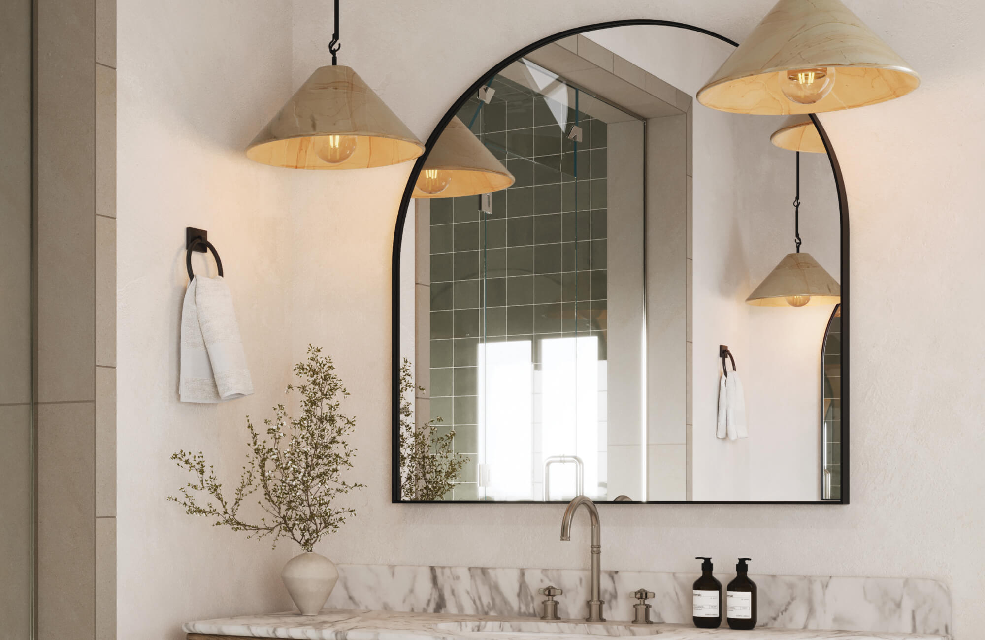 Arched black-framed mirror above marble vanity, accented by cone pendant lights and brushed nickel faucet.