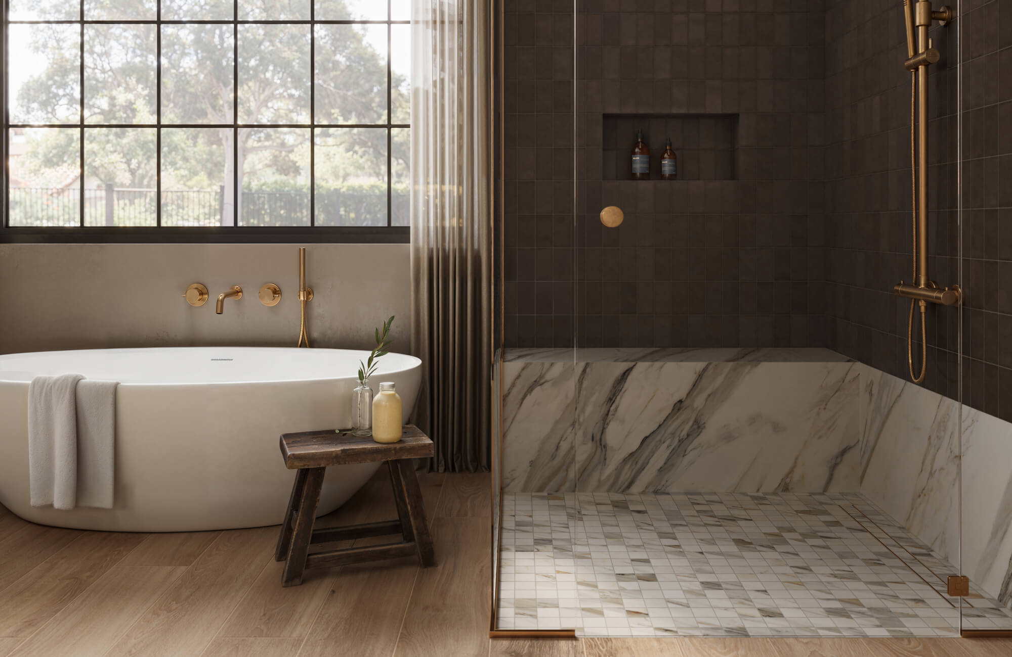Modern organic bathroom with marble look shower floor tile and dark brown subway tile walls, freestanding tub, brass fixtures, and wood look tile flooring.