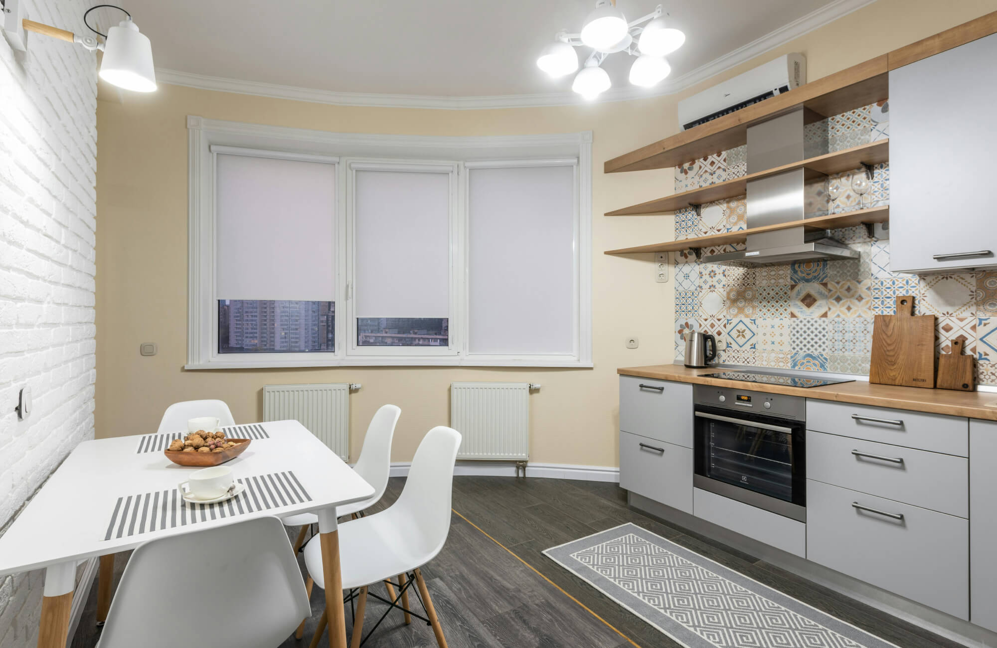 Geometric-patterned kitchen rug in soft grey and white tones adds texture and comfort to the modern space.