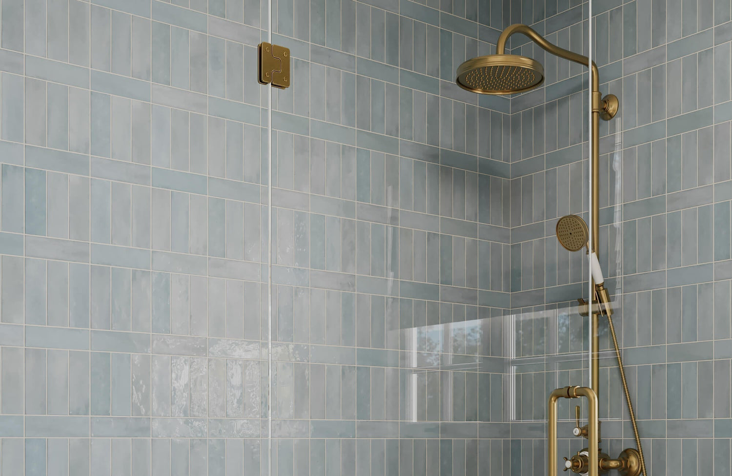 Glossy soft blue subway tiles in a mixed vertical and horizontal layout, paired with brushed brass shower fixtures.