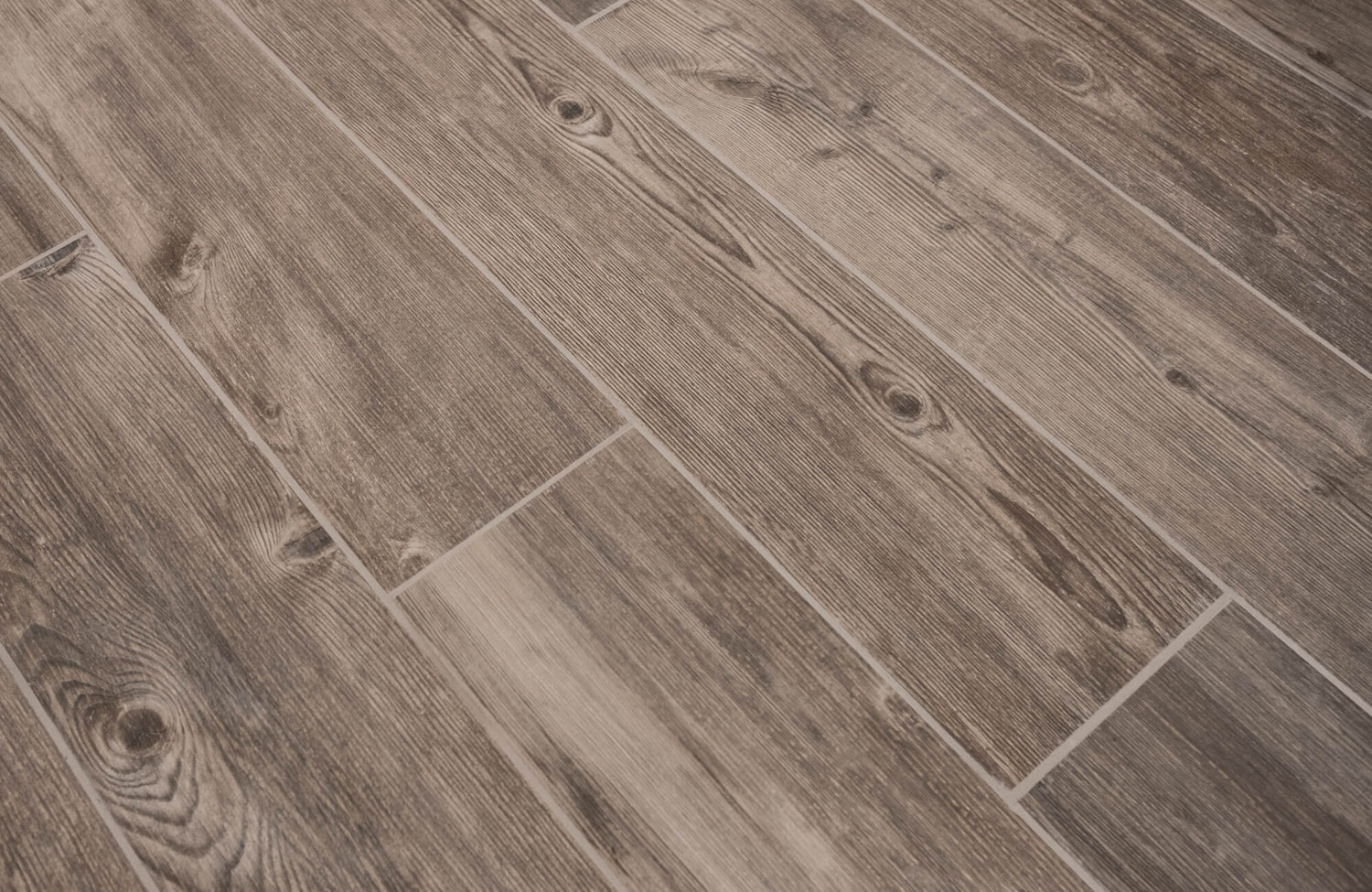 Wood look tile floor installed in a staggered pattern, showcasing natural grain variation and realistic plank movement across the surface.