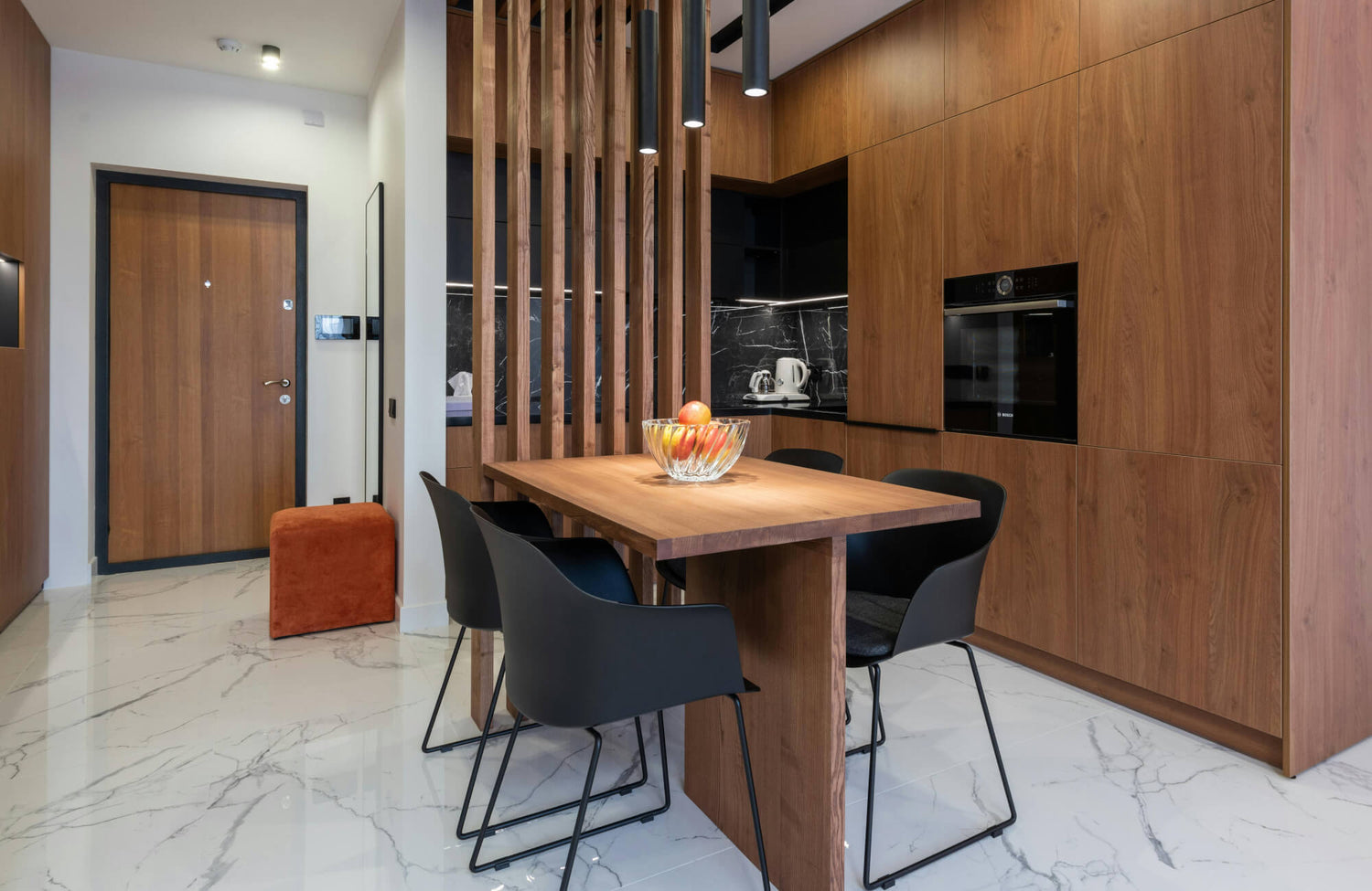 Contemporary kitchen featuring sleek wooden cabinetry, a natural wood dining table, and elegant marble-look flooring that adds a touch of luxury.