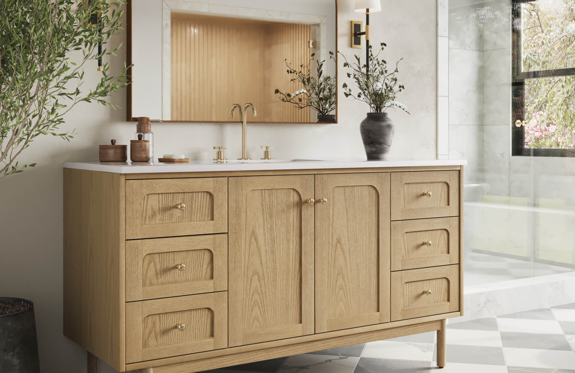 Light oak bathroom vanity with double undermount sink, set against a neutral wall with gold fixtures and black accent décor.