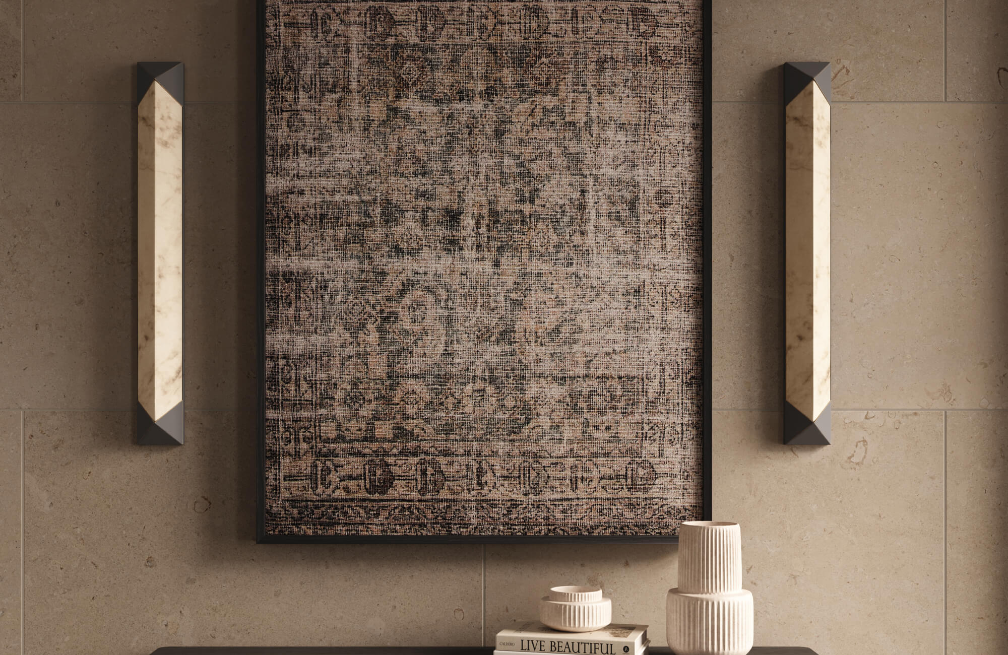 Framed textile wall art with vintage-inspired woven patterns displayed on a beige stone wall above a console table, styled with modern wall sconces and neutral ceramic decor.