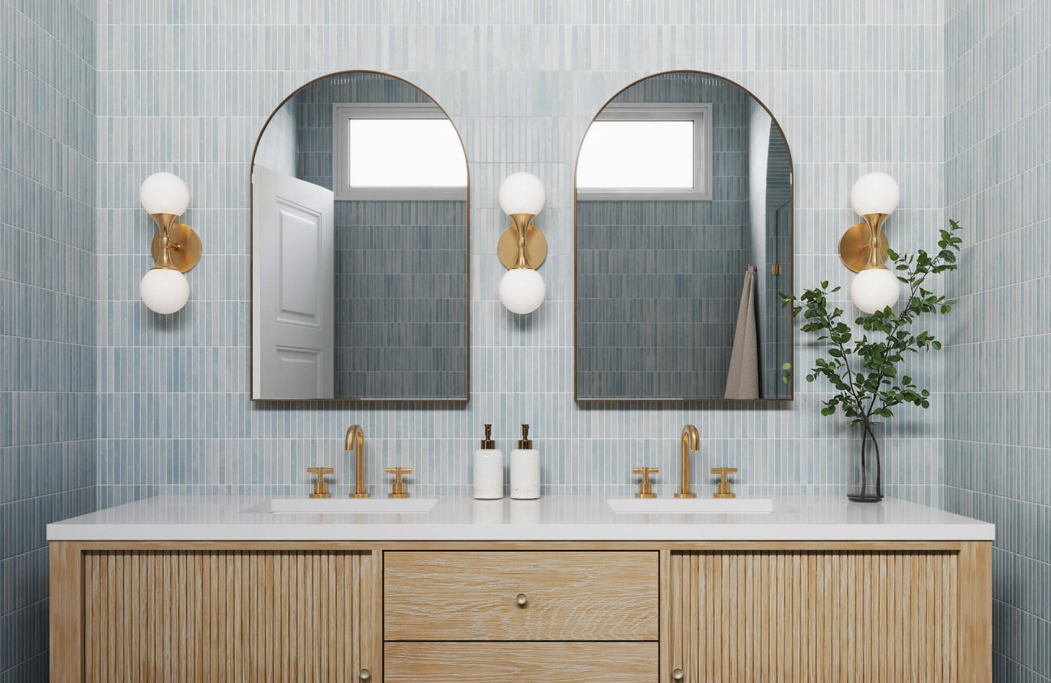 Double-sink vanity with fluted wood cabinets, brass faucets, and arched mirrors, styled in a modern bathroom with blue ceramic wall tile.