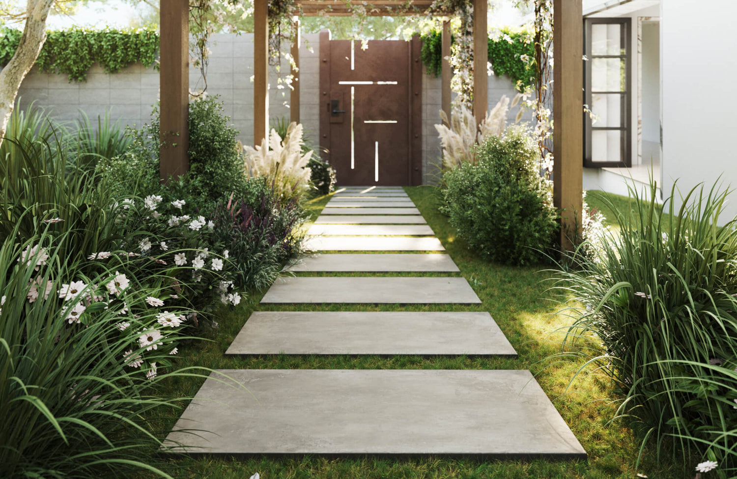 Elegant concrete look porcelain pavers form a sleek garden pathway, bordered by lush greenery and soft white flowers under a vine-draped pergola.