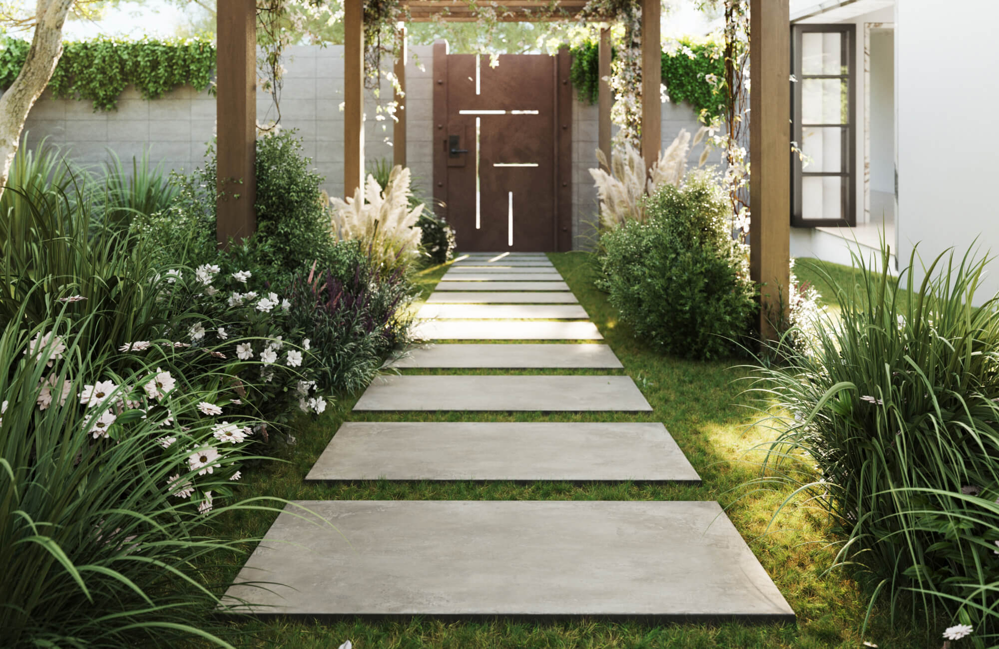 Elegant concrete look porcelain pavers form a sleek garden pathway, bordered by lush greenery and soft white flowers under a vine-draped pergola.