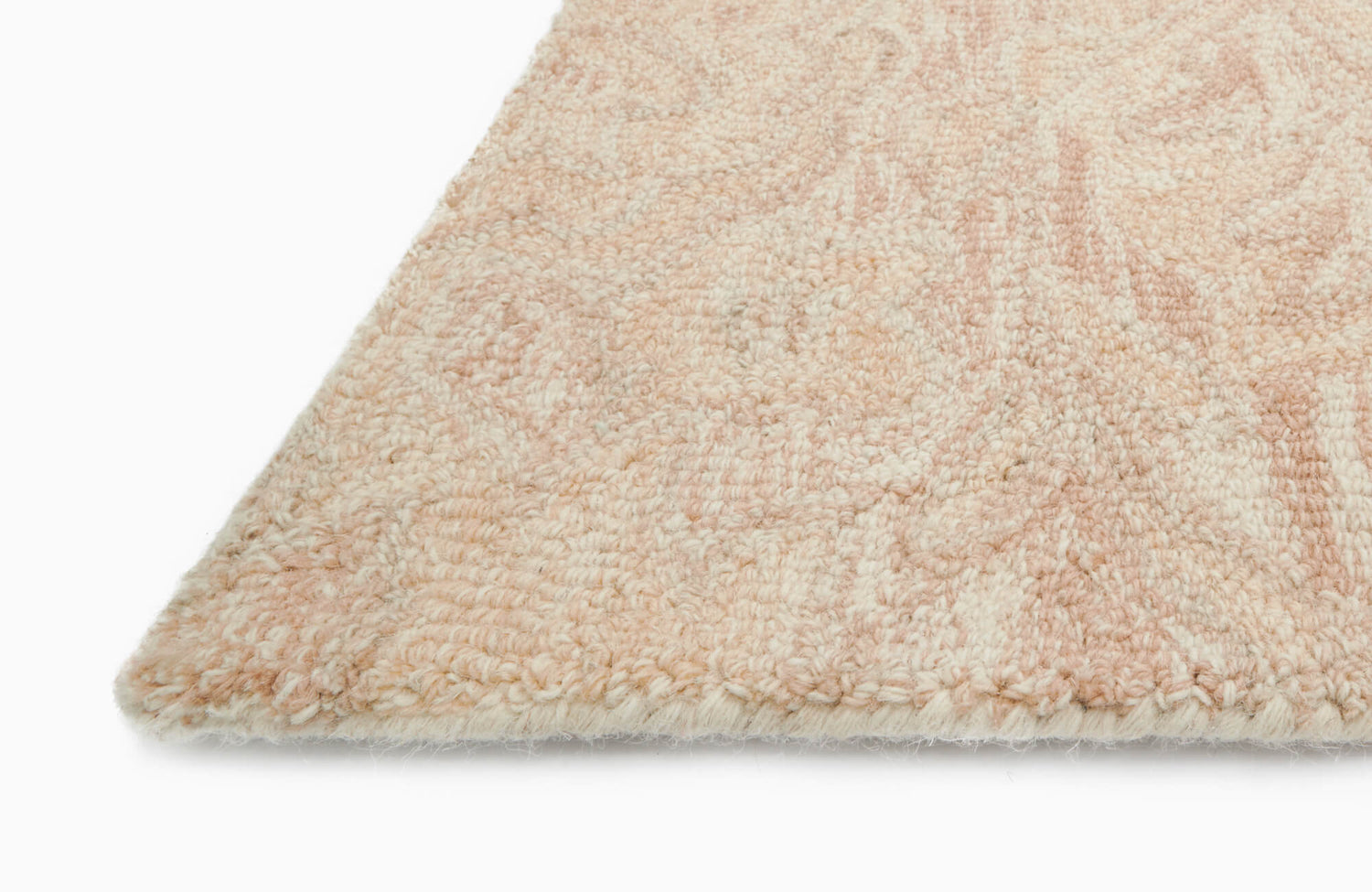 Soft wool pile rug in Primrose, featuring a delicate blend of blush and cream tones with a subtle, textured pattern for timeless elegance.