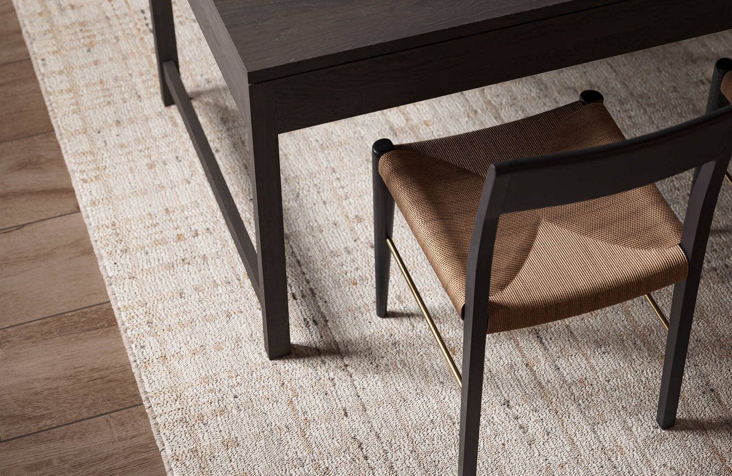 Close-up of a wool natural fiber rug beneath a dining chair and table, highlighting its dense weave, subtle tonal flecks, and durable texture that resists wear while maintaining a refined, long-lasting appearance.