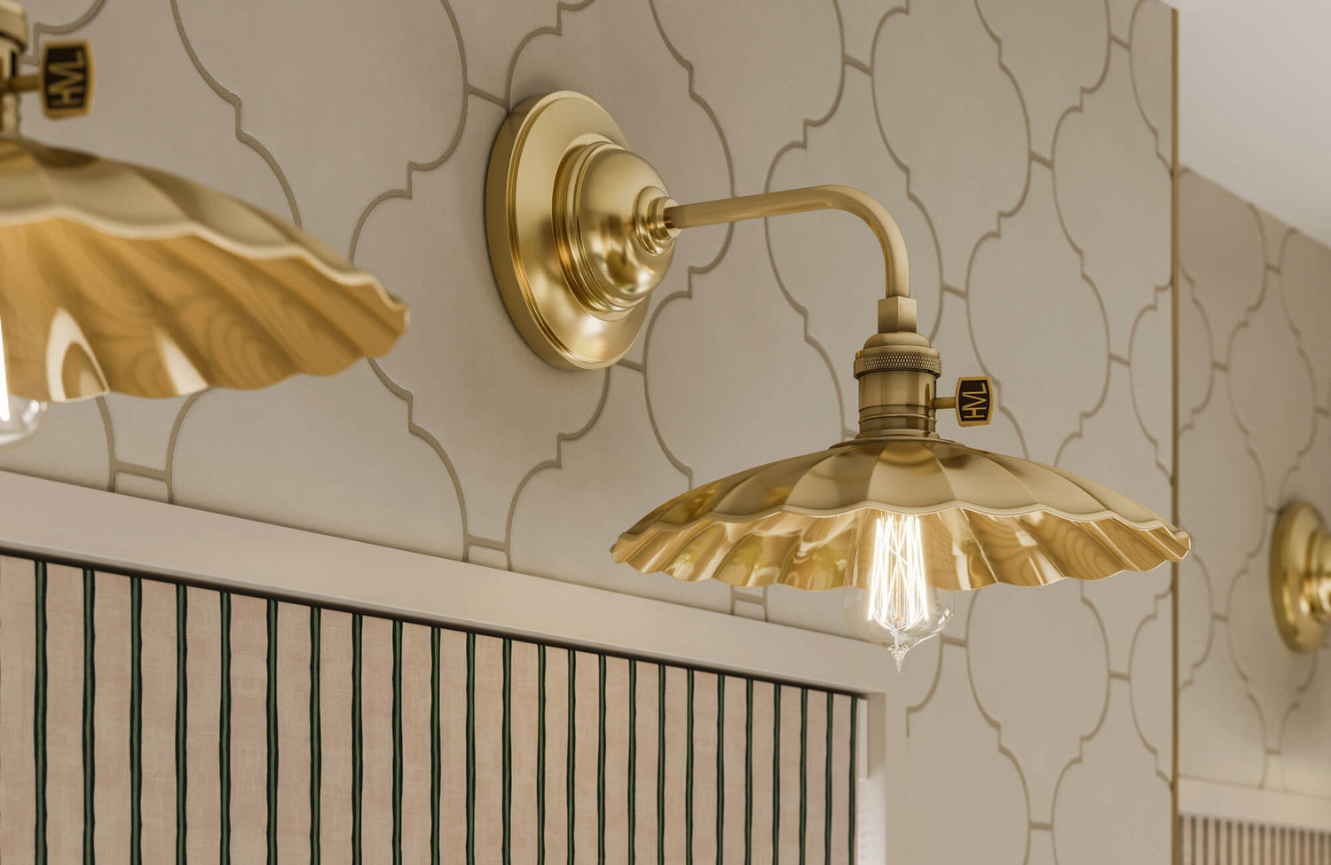 Close-up of decorative brass wall sconce with scalloped shade, Edison bulb, and Moroccan-style wallpaper for ambient lighting and vintage flair