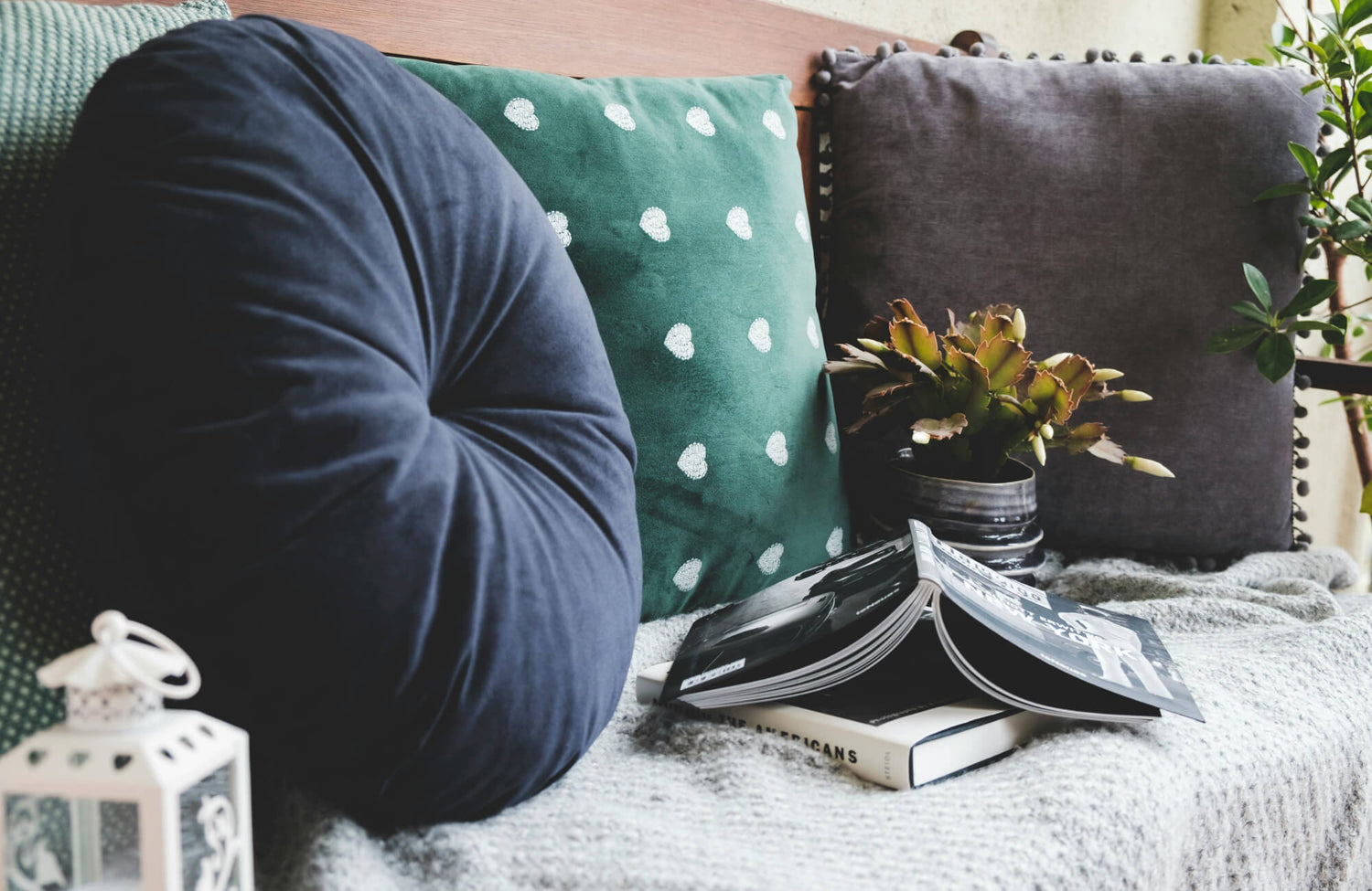 Decorative pillows in mixed shapes and designs, including a round tufted pillow, a patterned square pillow, and a textured accent pillow, showing variation in pillow types and styles.