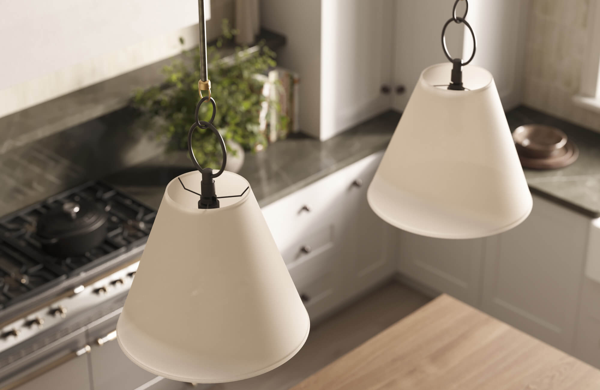 Overhead view of cone-shaped pendant lights with black hardware hanging above a modern kitchen with green stone countertops and white cabinets.