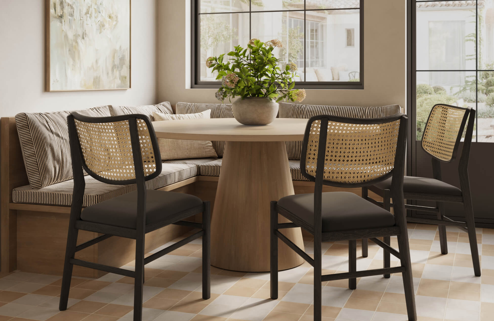 Cozy breakfast nook with a round pedestal table, striped banquette seating, and black rattan dining chairs on checkered tile flooring.