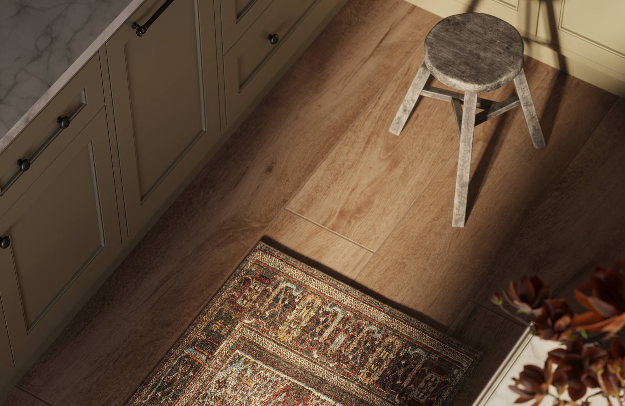Close view of natural wood-look porcelain tiles with realistic grain variation, accented by a traditional patterned rug and a weathered wooden stool.