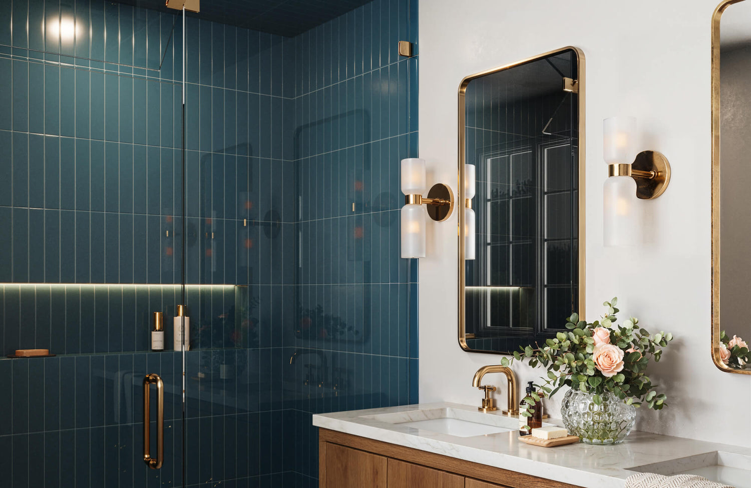 Modern bathroom with a teal vertical subway tile shower, glass enclosure, brass hardware, marble vanity, gold-framed mirrors, and wall sconces.