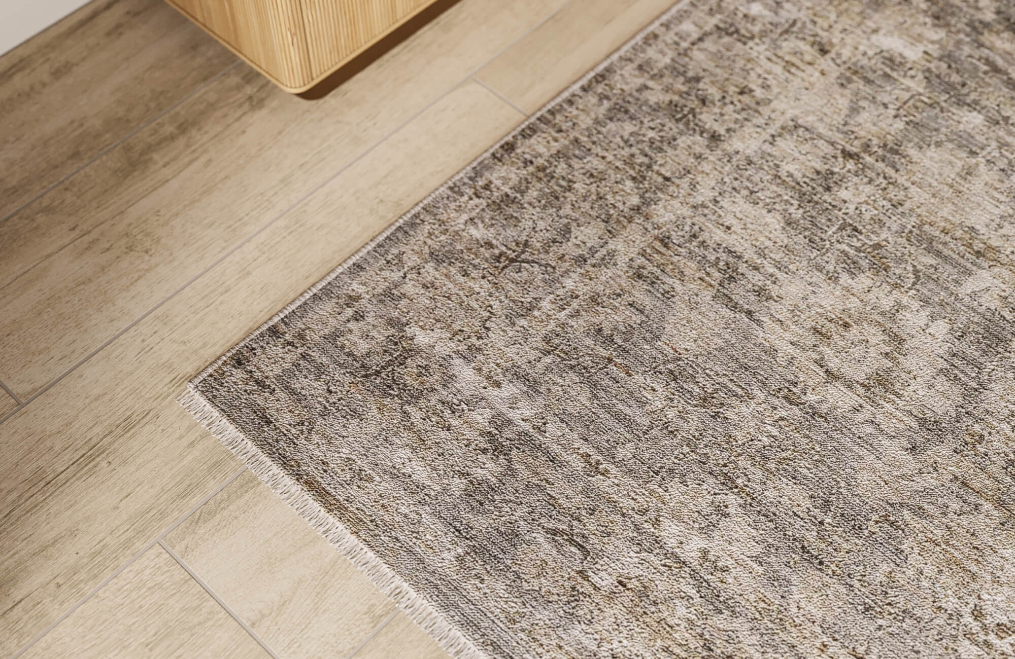 Soft beige wood effect tiles with gentle grain lines add warmth without heaviness, blending smoothly with the distressed rug and understated, natural-toned decor.