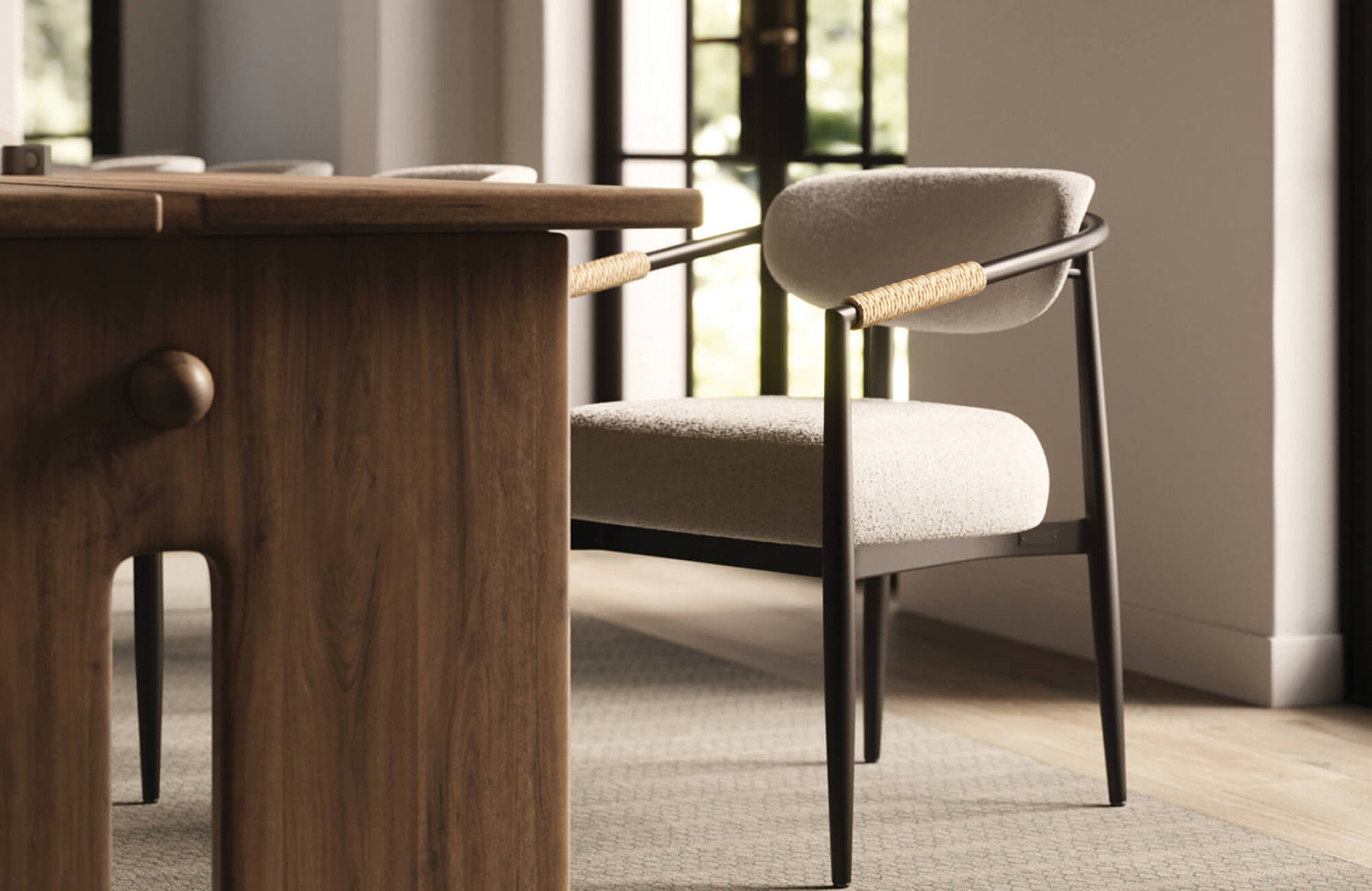 Light beige upholstered dining chair with black frame beside a warm wood table, creating a soft, balanced dining atmosphere.