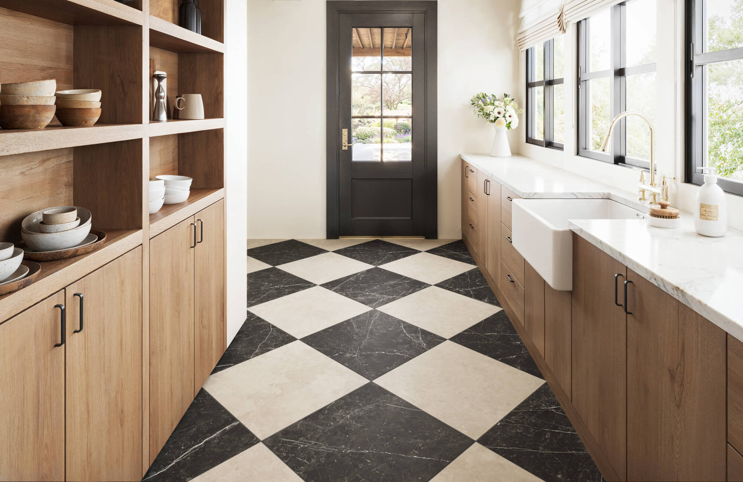Stylish kitchen with a bold black and white checkered marble floor, warm wood cabinetry, and elegant brass fixtures.