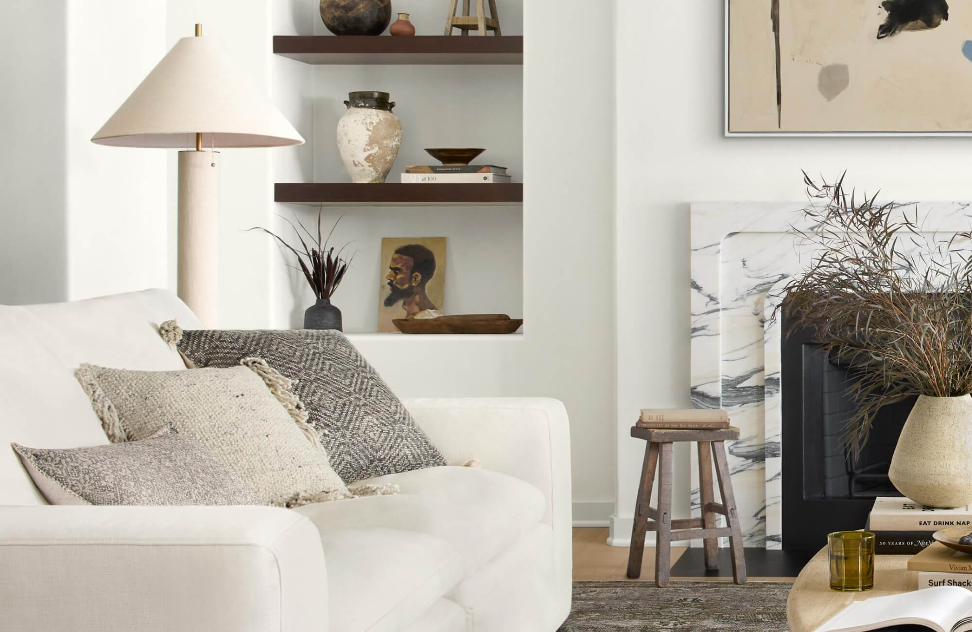Cozy neutral interior with textured decorative throw pillows and styled wall shelving decor that gives a calm and serene setting.