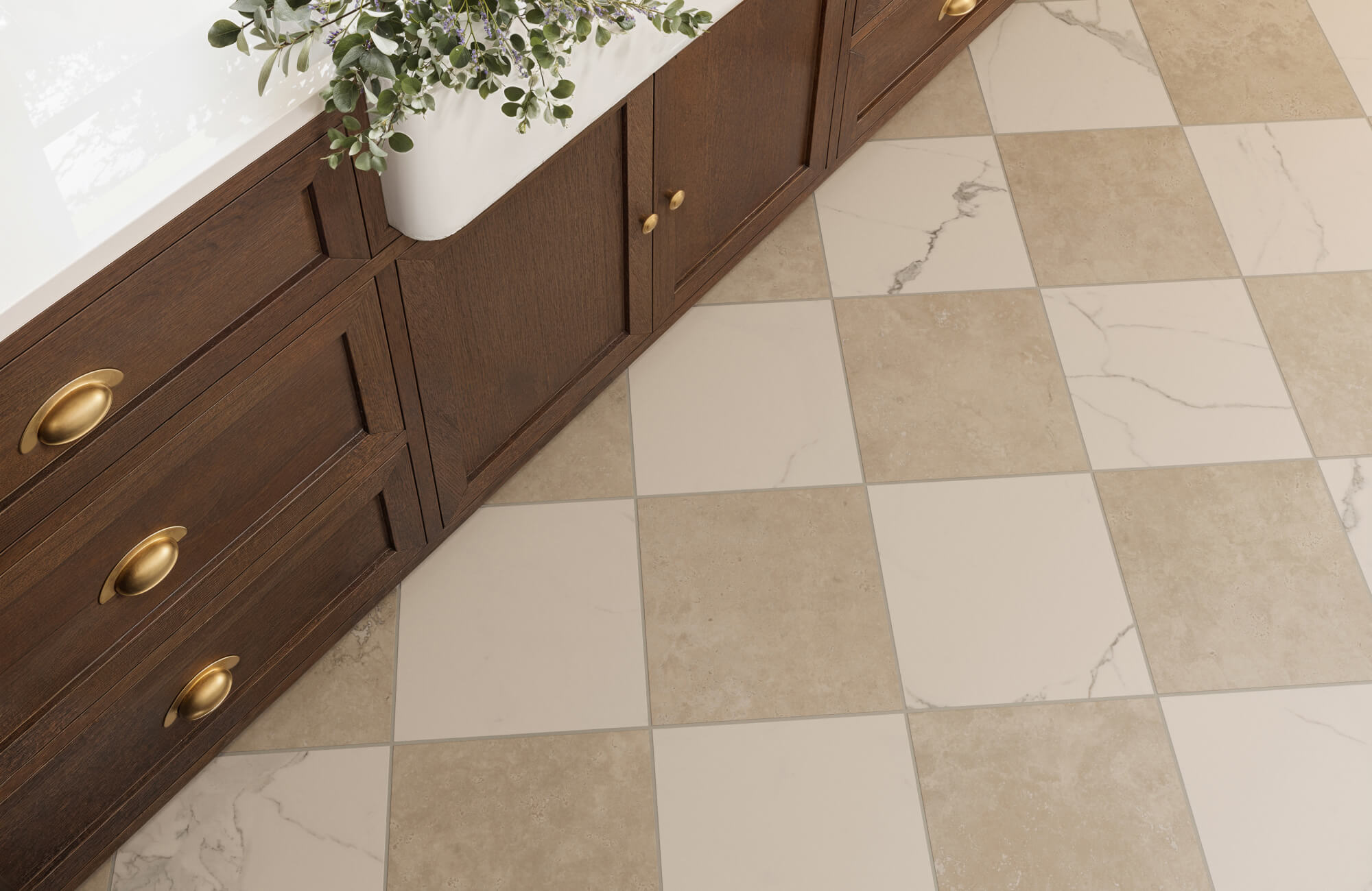 Checkerboard floor in a modern kitchen featuring beige and marble-patterned tiles, adding a classic yet elegant touch beside dark wood cabinetry with brass handles.