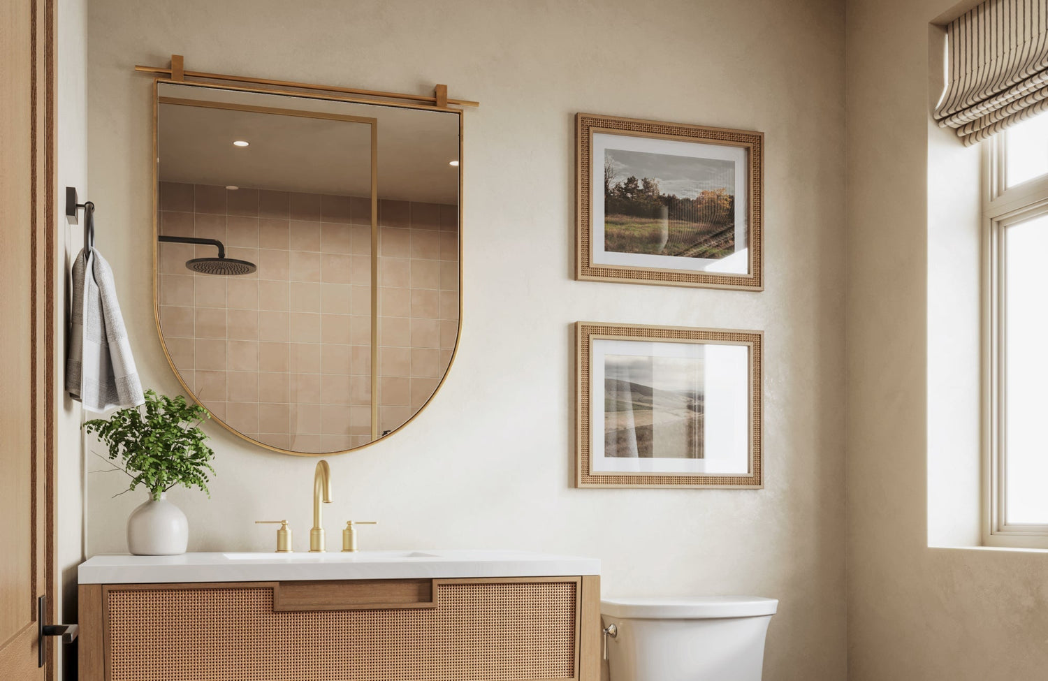 Gold-framed half-arch vanity mirror above a modern rattan vanity, paired with soft neutral tones and brass fixtures