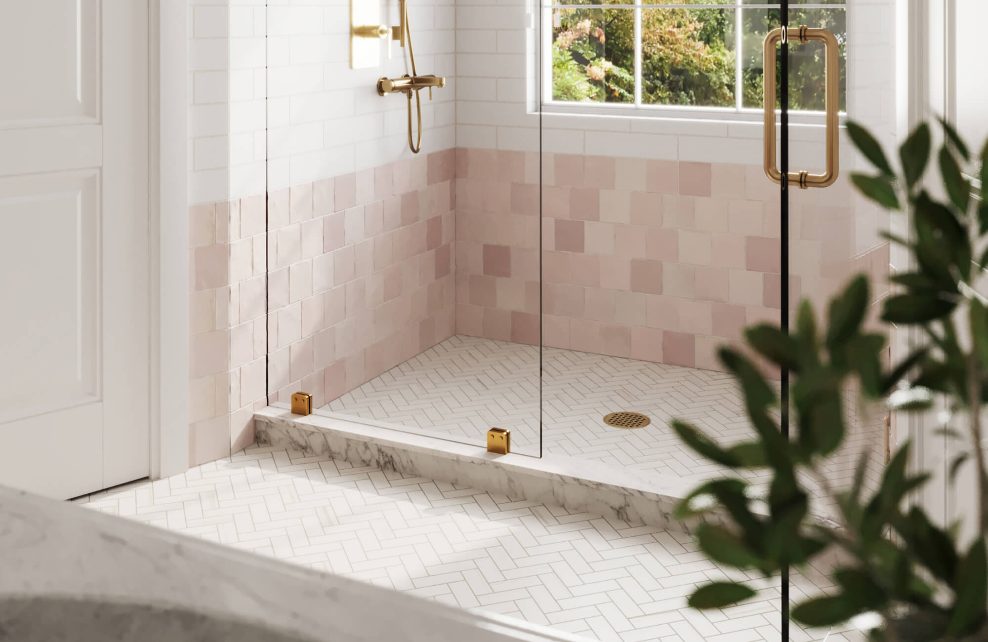 Elegant walk-in shower with blush pink wall tiles, white mosaic herringbone floor tile, and gold hardware accents.