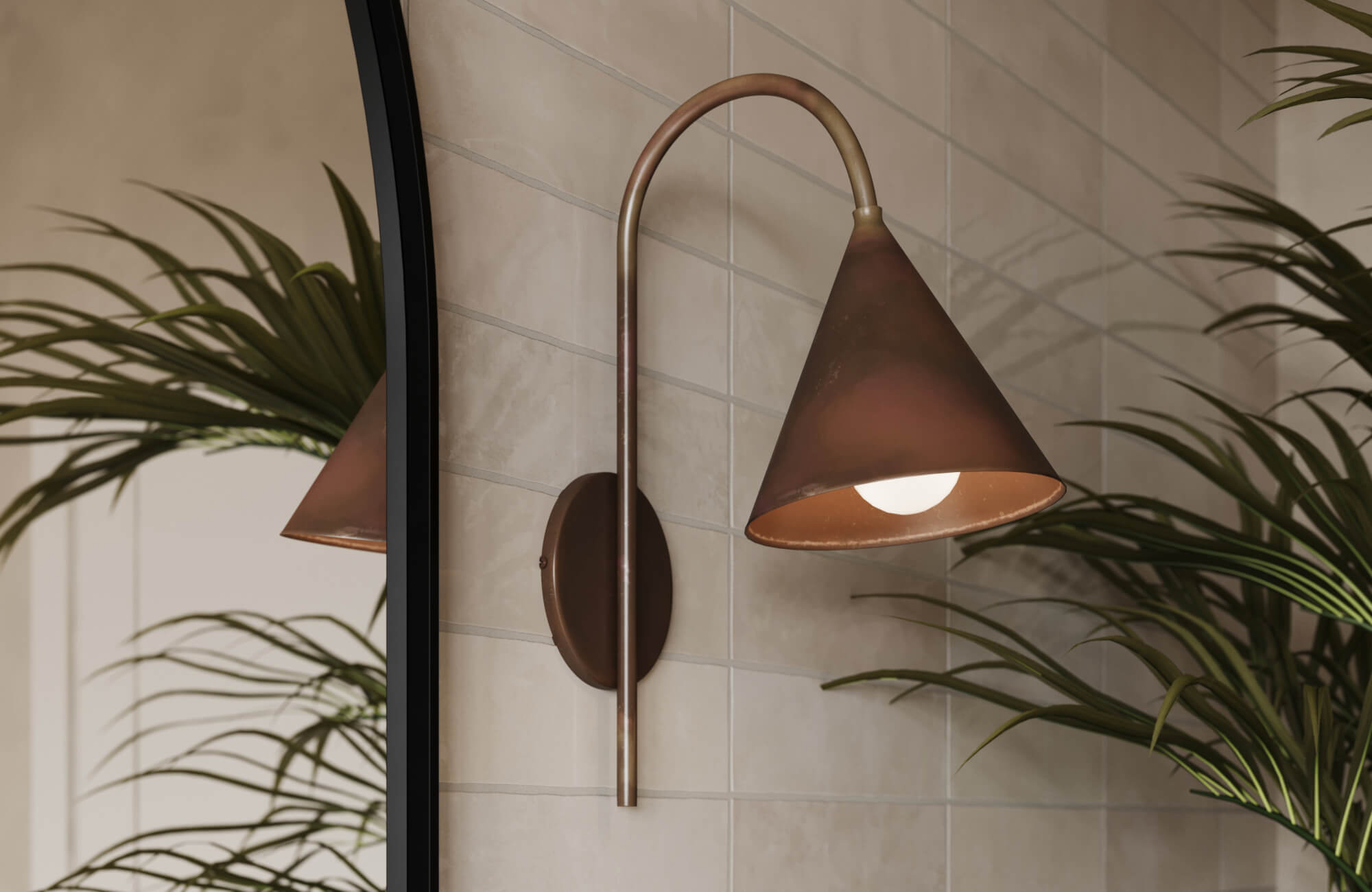 Cone-shaped bronze sconce adds sculptural elegance to a bathroom, paired with neutral tile and leafy greenery for a serene vibe