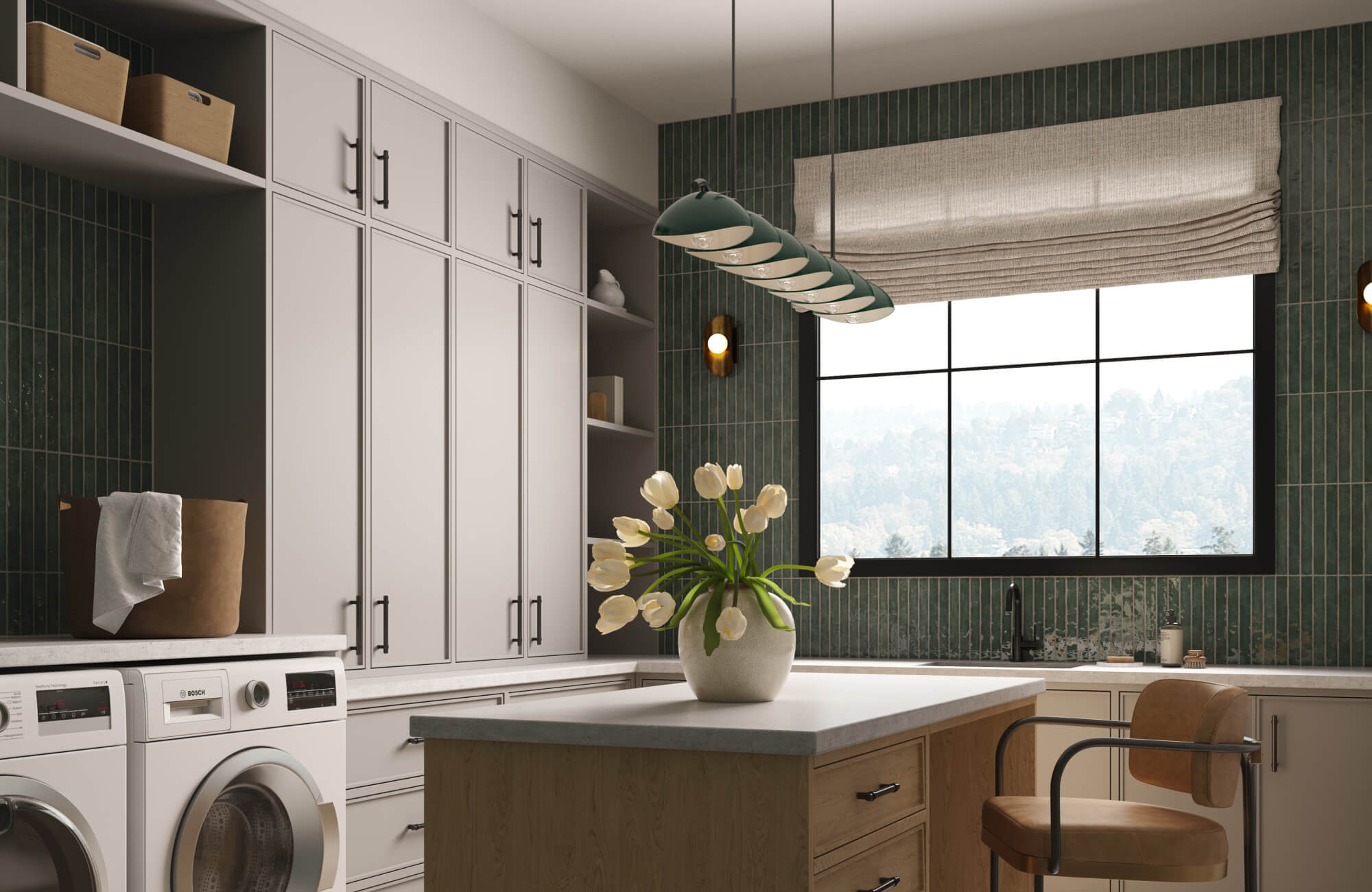 A bright laundry room with tall cabinetry, green vertical tile walls, a central island, and a modern linear light fixture, finished with a large window and fresh tulips.