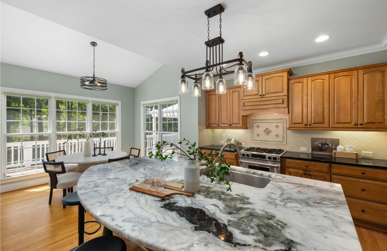 Curved kitchen island with bold-veined marble countertop, showcasing dramatic natural patterns ideal for statement kitchen designs and high-end marble selections.
