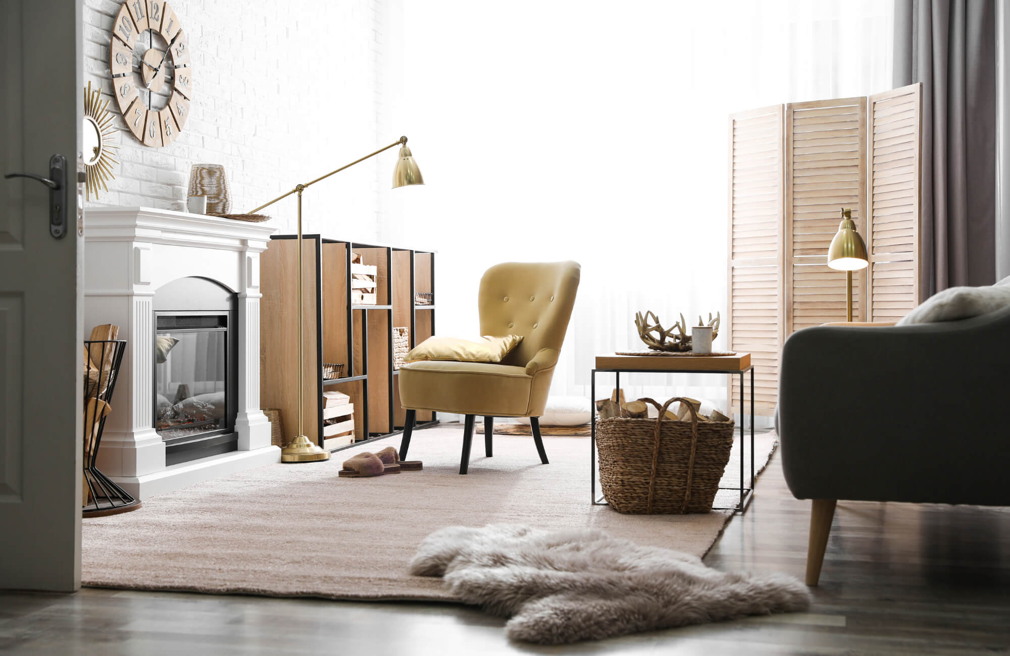 Warm living room with a beige area rug, mustard armchair, fireplace, and soft natural light creating a cozy, inviting seating space.