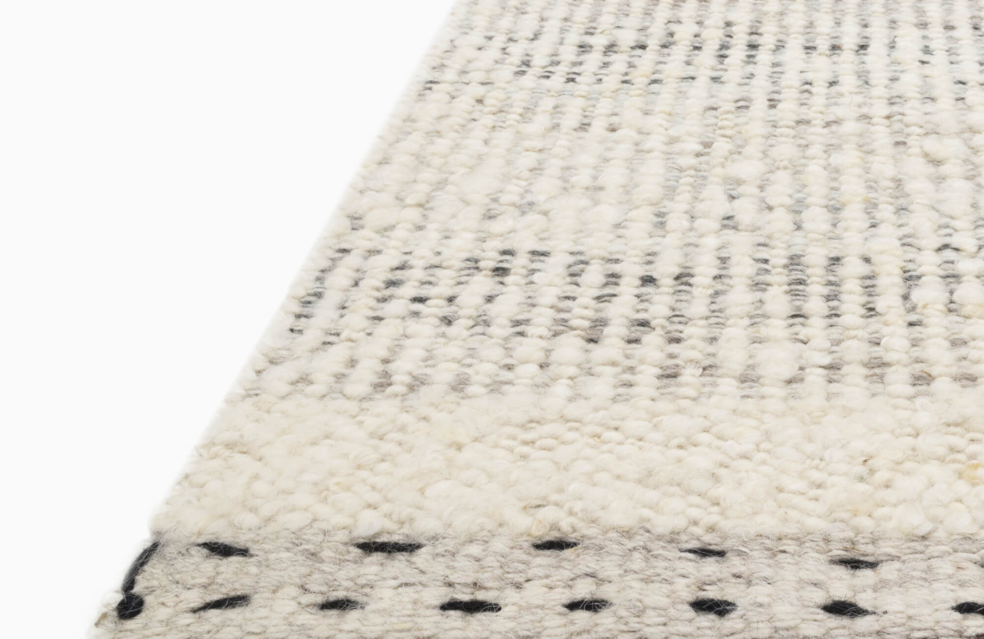 Close-up of a textured wool rug featuring a subtle black and white checkered pattern with handwoven detailing, exuding cozy, artisanal charm.