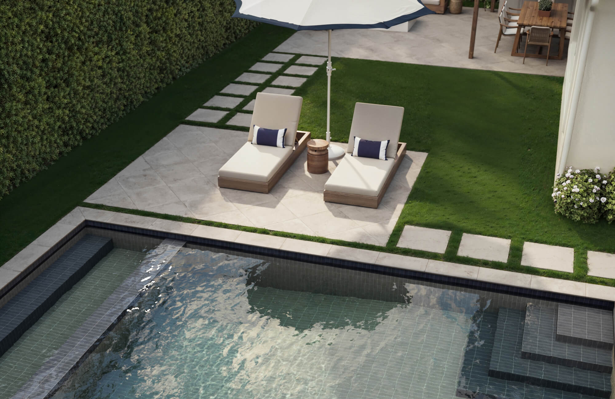 Elegant outdoor poolside area featuring light cream porcelain stone tiles in a diamond pattern, paired with lush green grass accents.