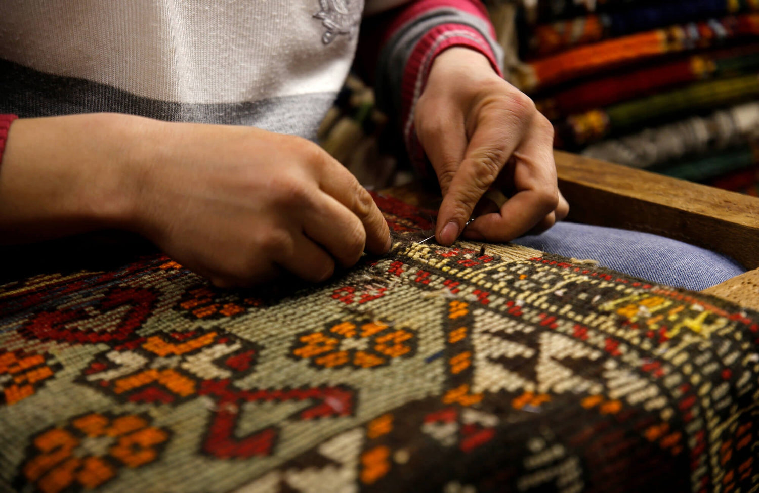 A skilled artisan meticulously weaving a traditional rug by hand, showcasing intricate patterns and vibrant colors in a detailed textile design.